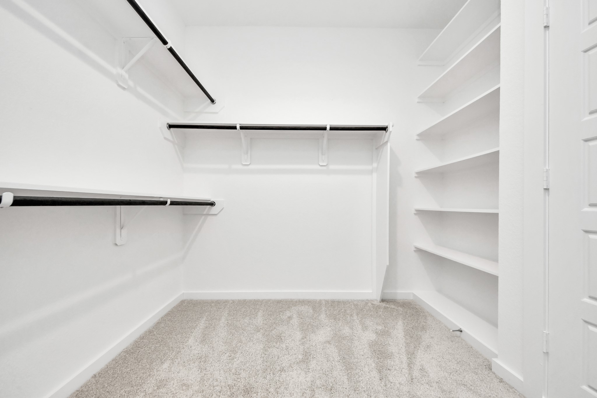 Walk-in closet that epitomizes luxury and practicality. This generously sized space features built-in shelving, offering abundant room for impeccable organization. High ceilings and recessed lighting create a bright and welcoming ambiance.