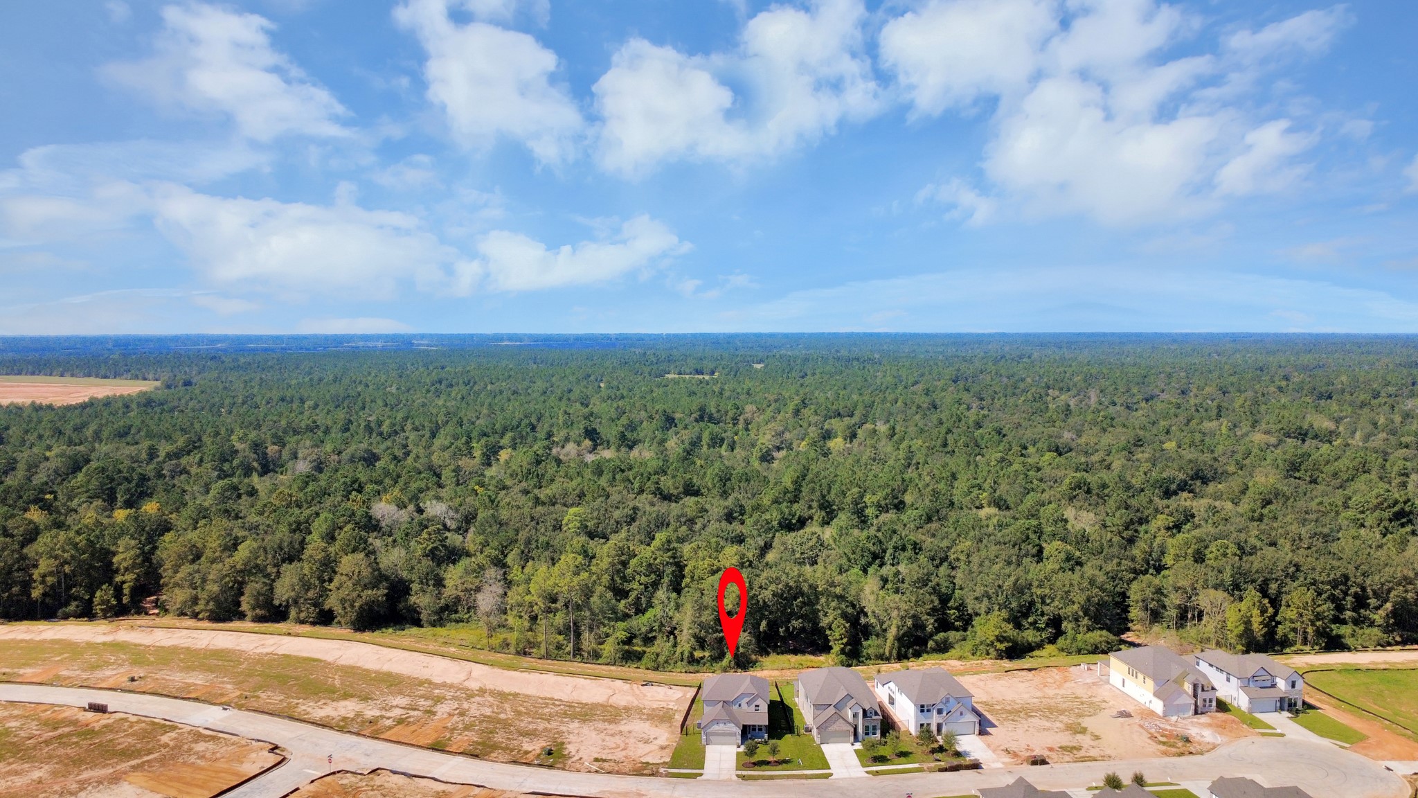 An aerial view of a spacious subdivision lot, highlighting a well-maintained yard and a fully fenced perimeter, offering both privacy and expansive outdoor space.