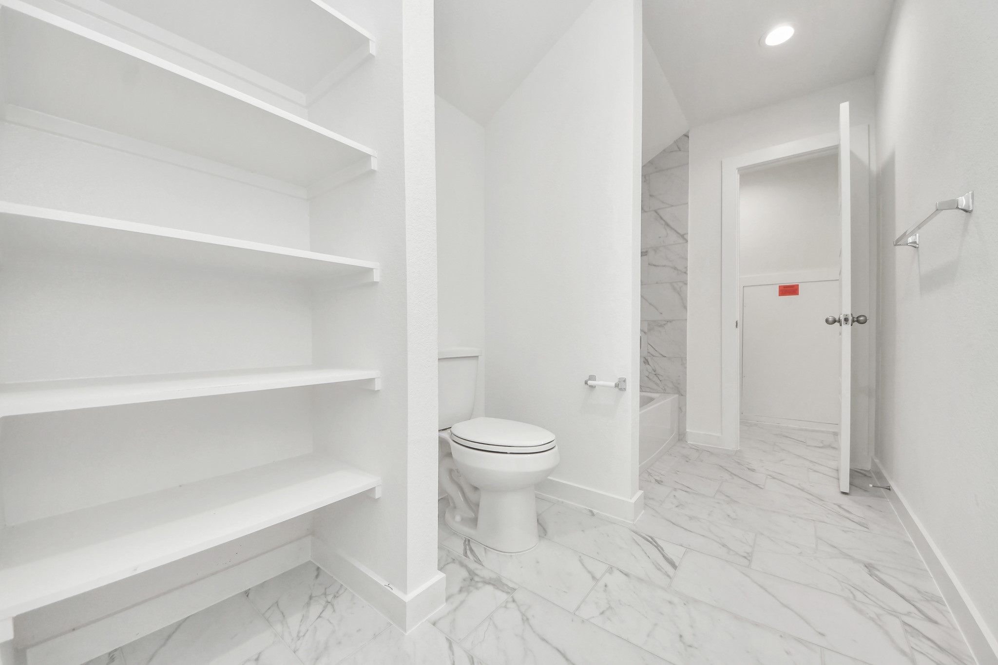 Experience convenience in the secondary bathroom, designed for Jack and Jill arrangements, now with a separate vanity area. This well-appointed space showcases stylish tile flooring, a bath/shower combo with an elegant tile surround, and light-stained wood cabinets. The beautiful light countertop adds a touch of sophistication, combining functionality and aesthetics seamlessly.