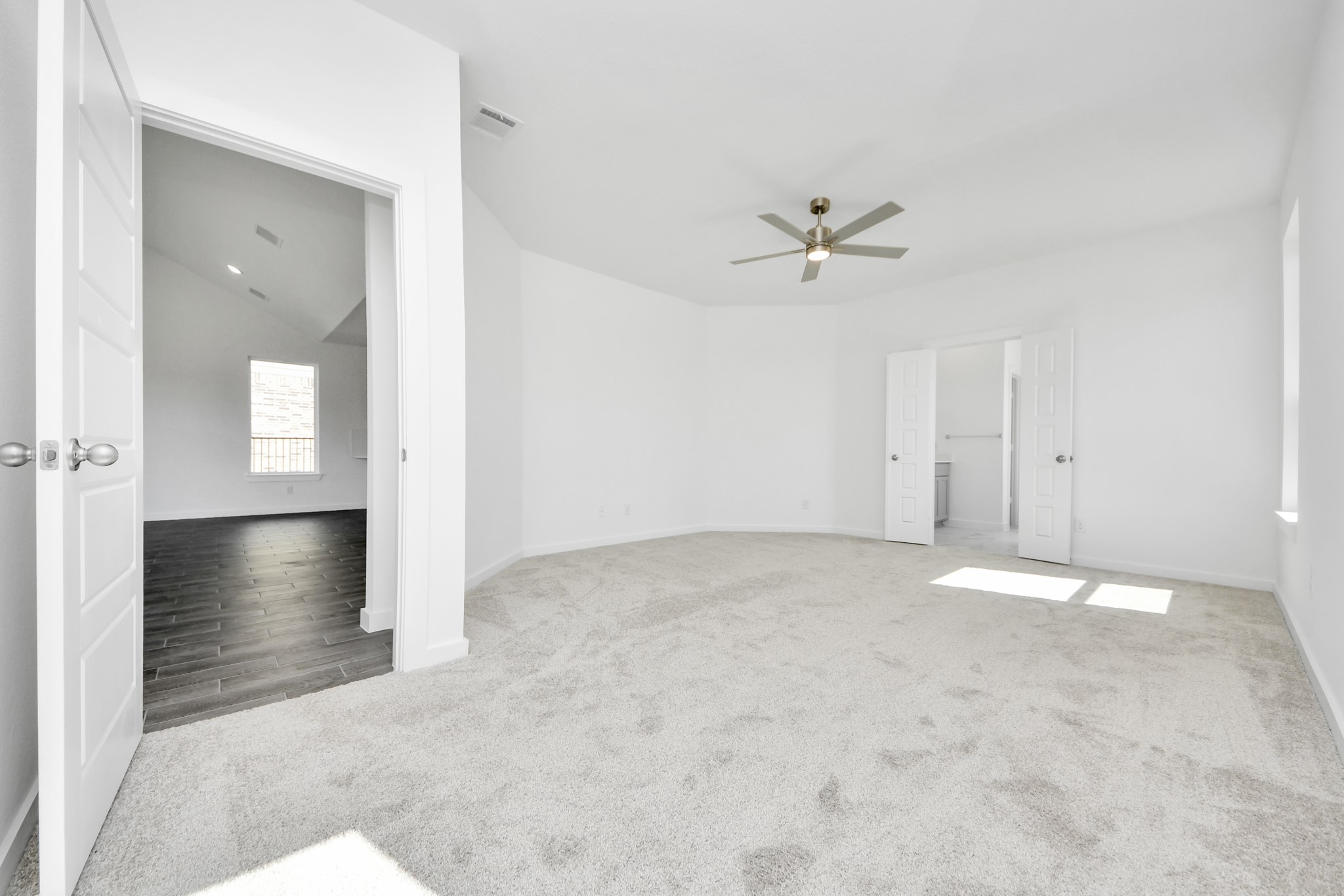 Escape and relax in the exquisite primary suite, a haven to unwind after a long day. The spacious room, located on first floor, boasts plush carpeting, soothing paint tones, high ceilings, and expansive windows adorned with privacy blinds.
