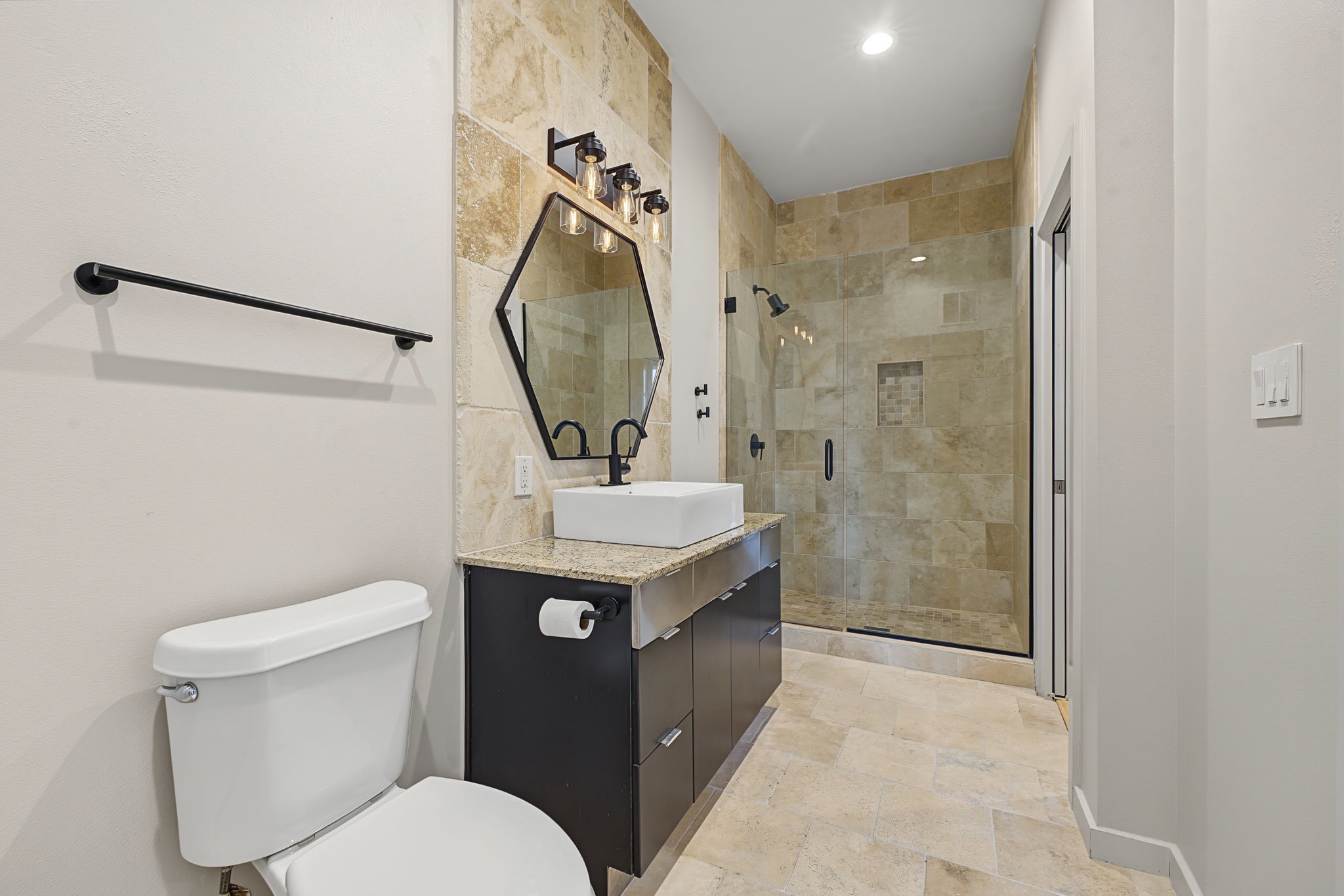 Thoughtfully Designed for Everyday Living! This stylish full bathroom offers the convenience of dual access from both the bedroom and the hallway near the kitchen. The smart layout provides easy access for guests while maintaining a private connection to the bedroom suite!