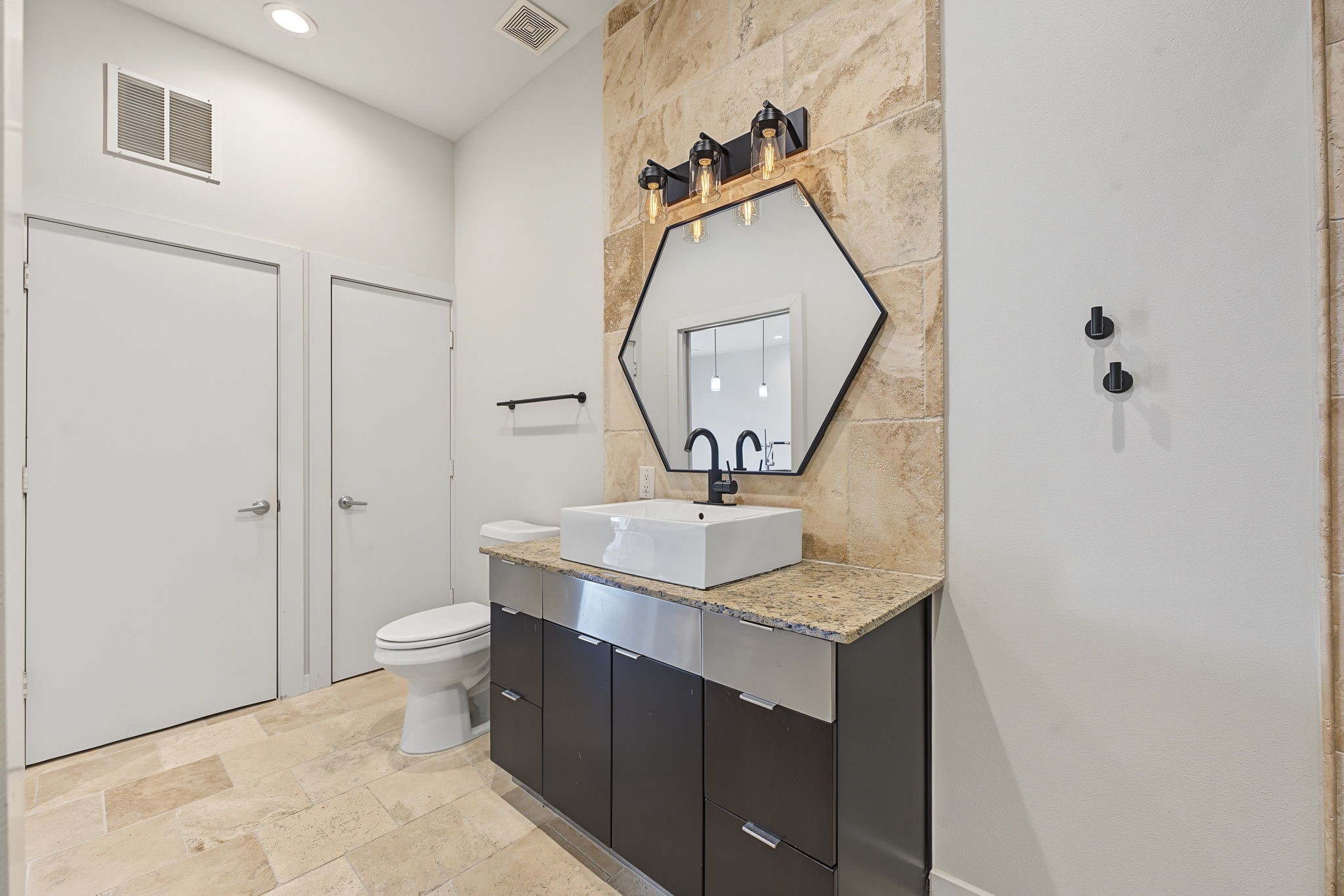 Modern Style in Every Detail! Beautiful travertine tile flooring, rich granite countertops, and sleek European-style cabinetry create a sophisticated, contemporary atmosphere. Recessed lighting complements the clean lines and thoughtfully selected finishes, bringing together style and everyday functionality.