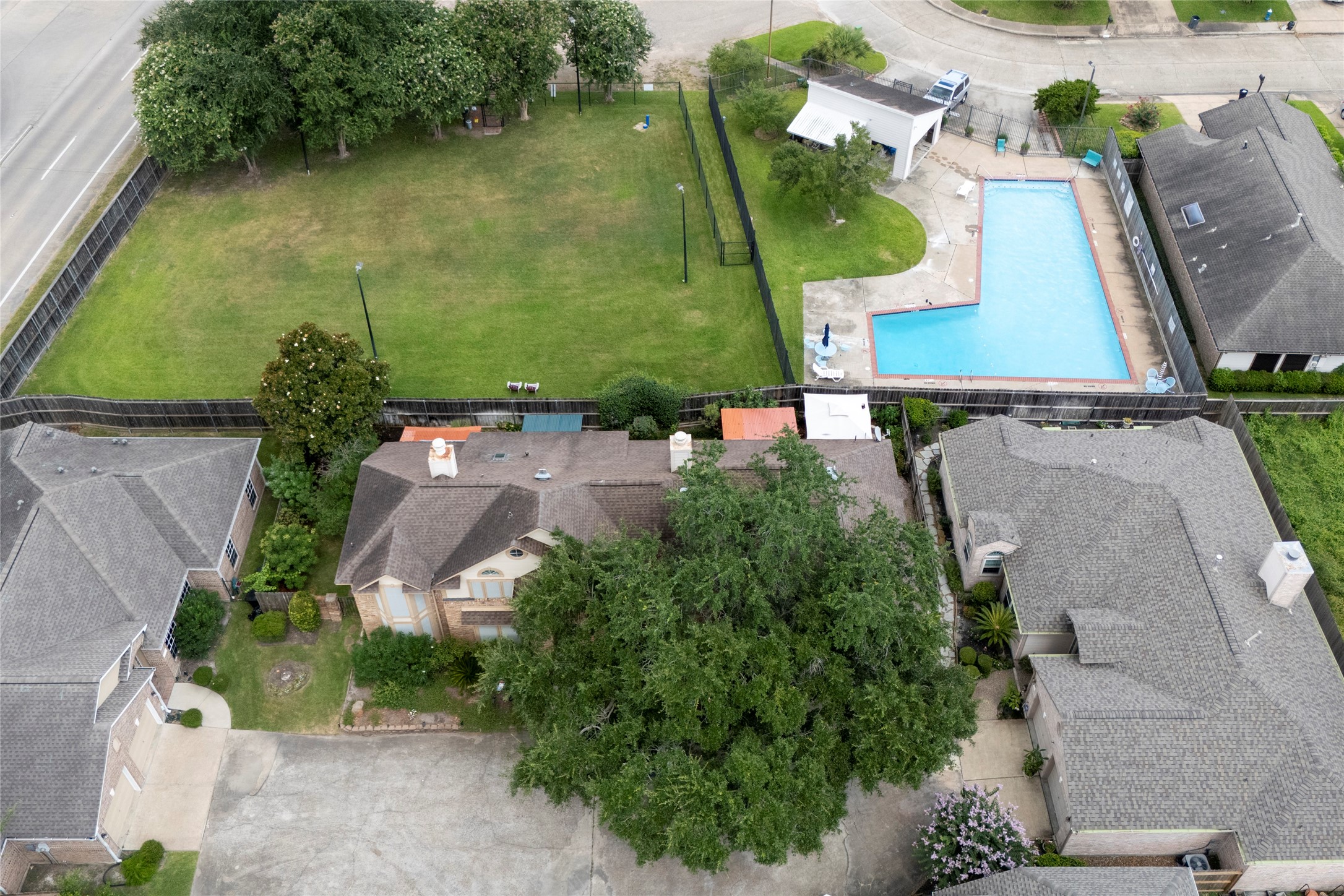 An aerial drone view showcasing the home's location within the Stonehenge community, just steps from the neighborhood pool and green space  a great lifestyle perk for future homeowners.