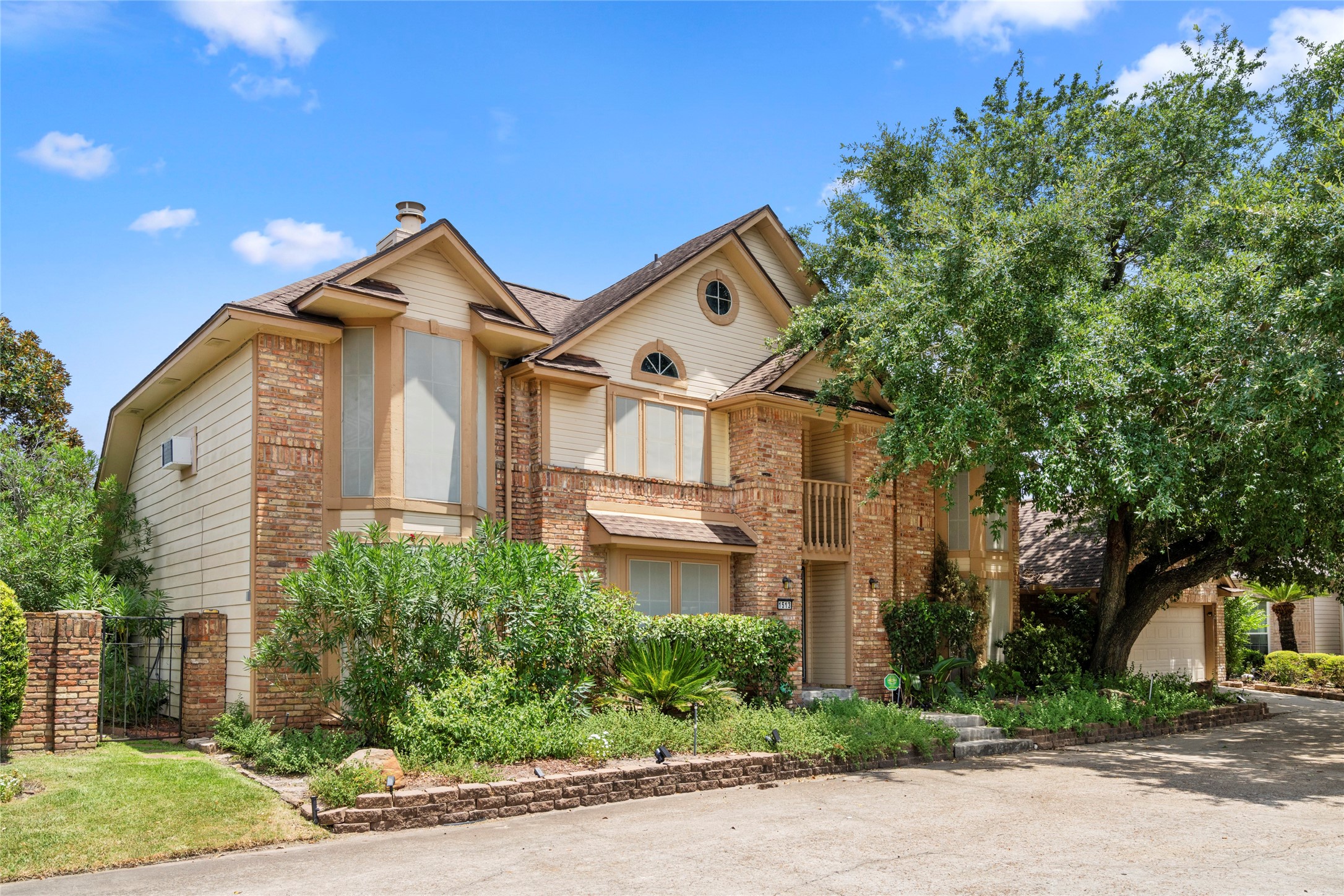 Another angle of the front exterior, drawing attention to the architectural charm of the arched windows and the well-manicured greenery framing the entry.