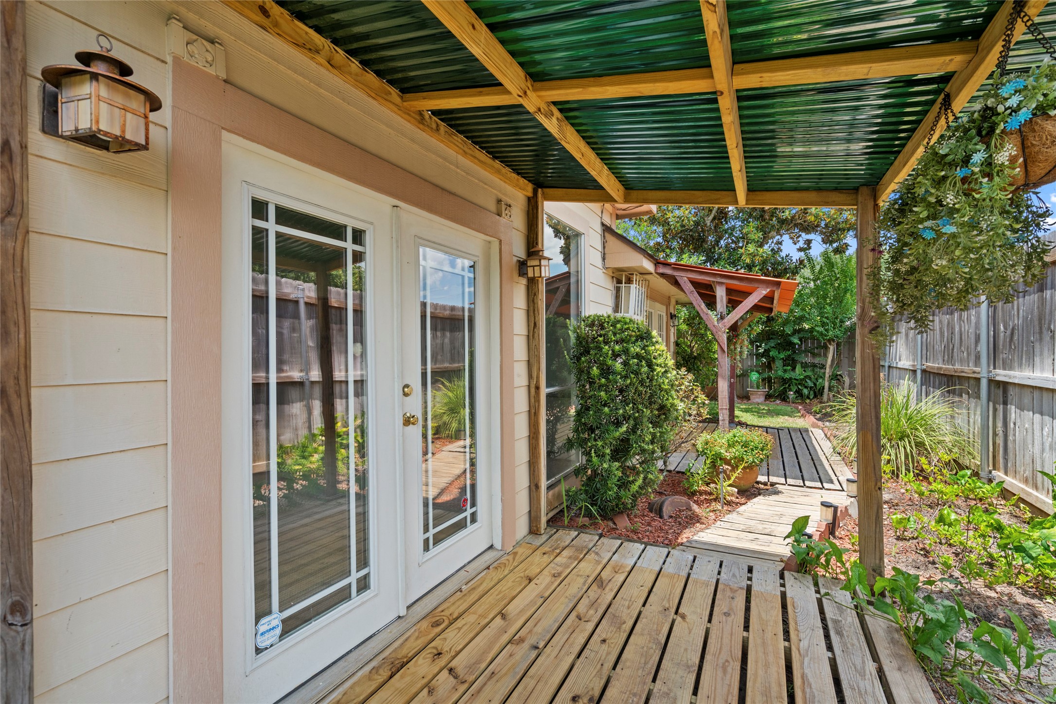 A covered patio area with a wooden pergola, offering additional shaded space for outdoor enjoyment.