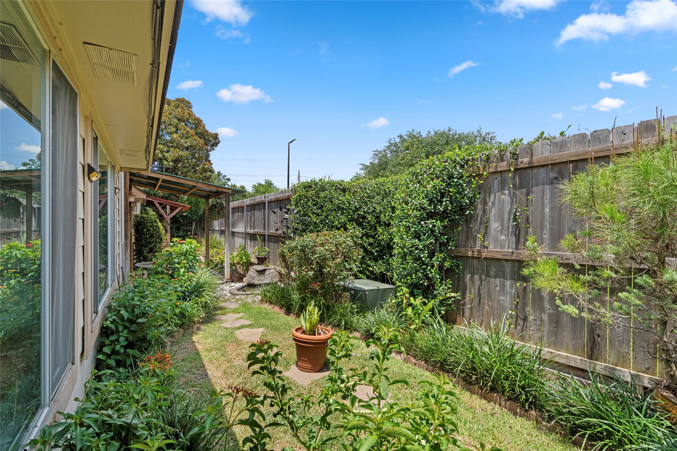 A side yard garden path, showcasing the lush, private greenery that surrounds the home.