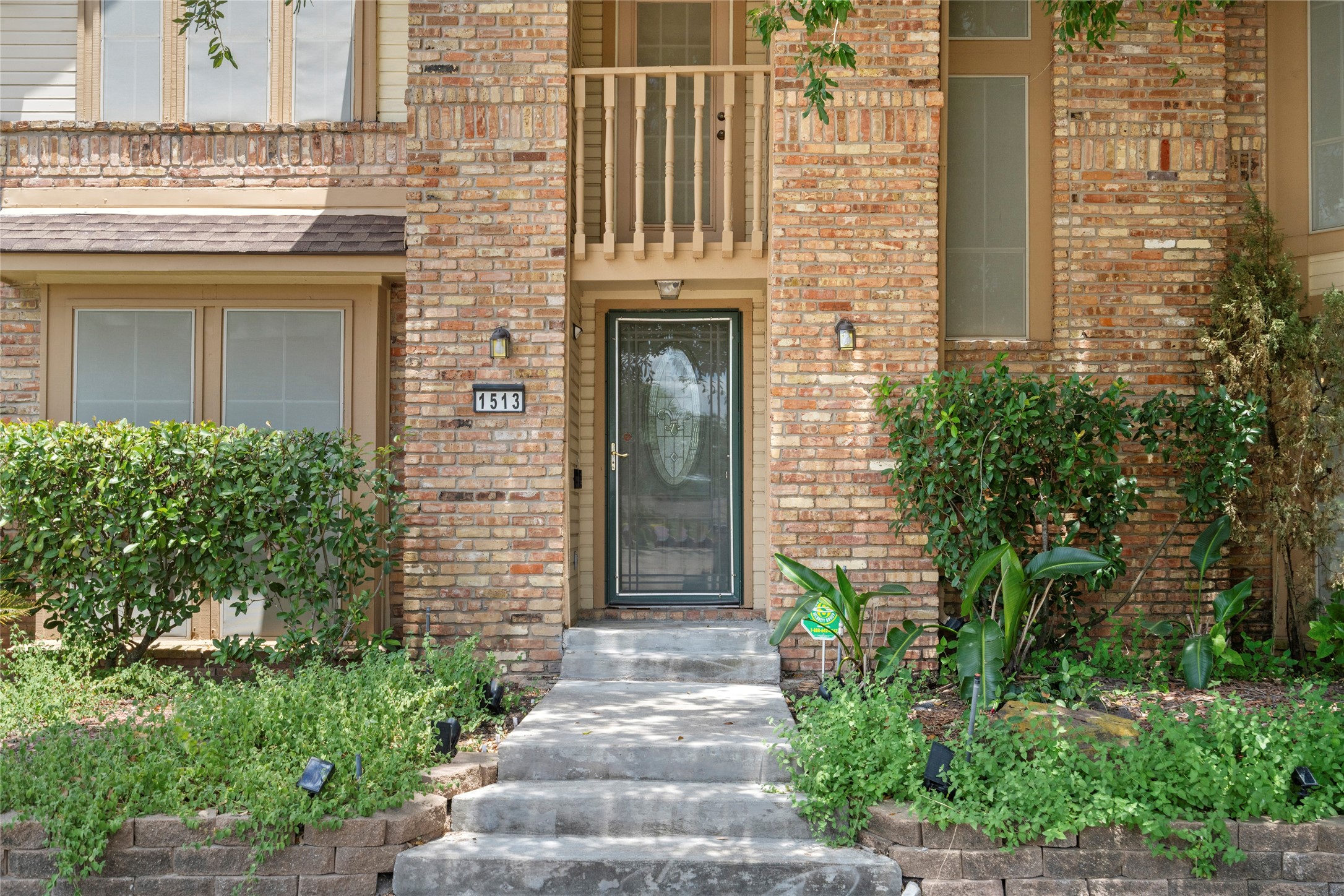 A close-up of the front entry, featuring the elegant door, stone steps, and lush landscaping that create a warm first impression for guests.