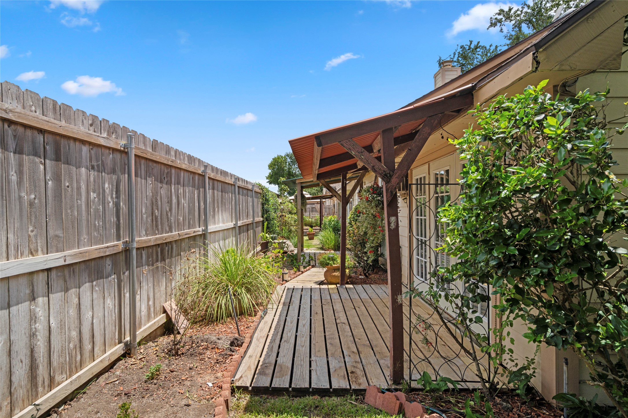 A backyard pergola-covered walkway, adding charm and functional shade to the outdoor living space.