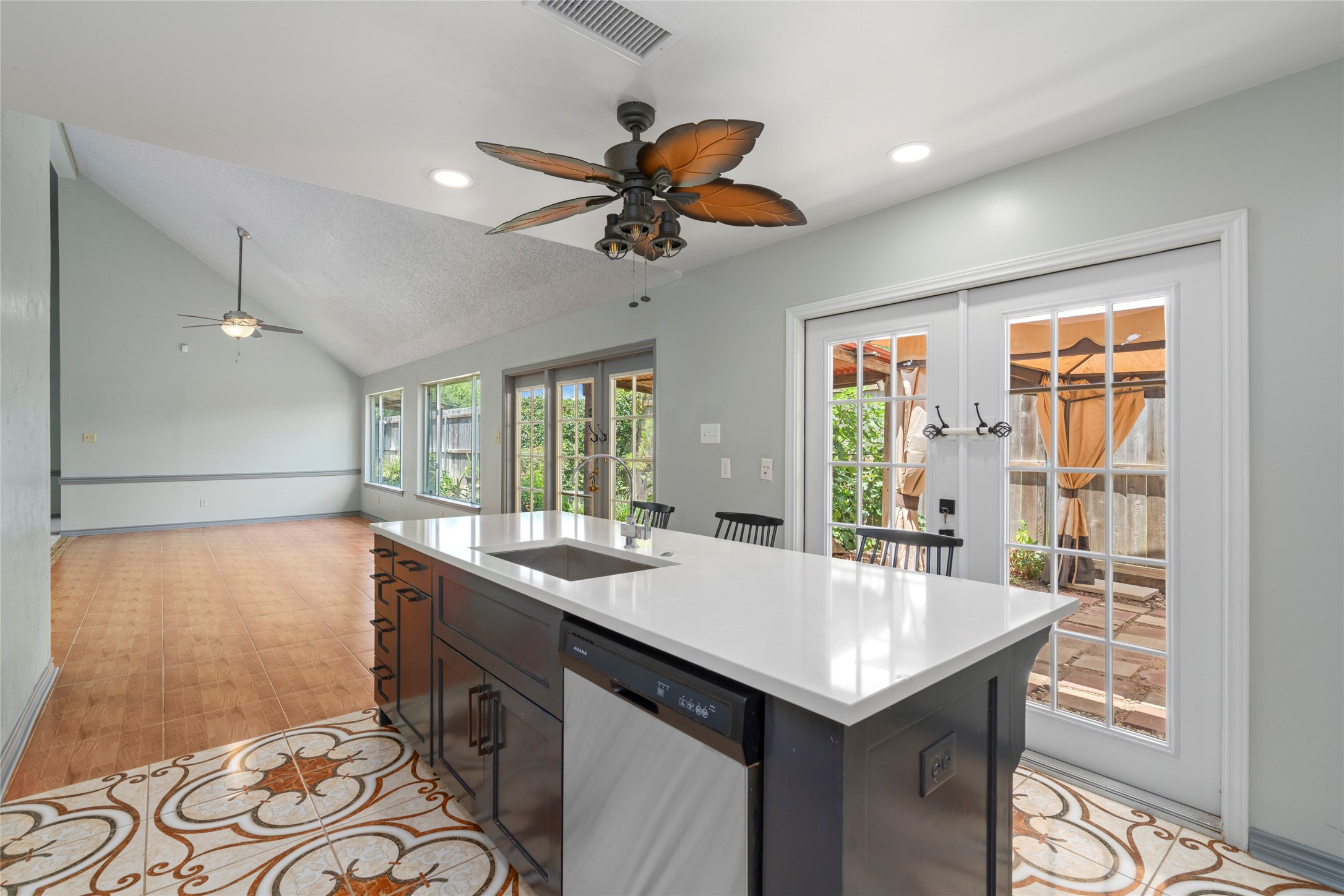 A view of the kitchen island opening toward the back door, emphasizing the easy indoor-outdoor flow for entertaining.