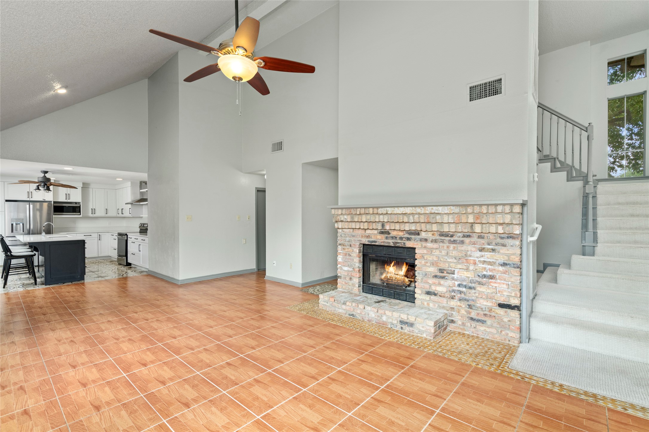The vaulted living area with its cozy fireplace, illustrating how the high ceilings and open sightlines make this the heart of the home. The vaulted living area with its cozy fireplace, illustrating how the high ceilings and open sightlines make this the heart of the home.