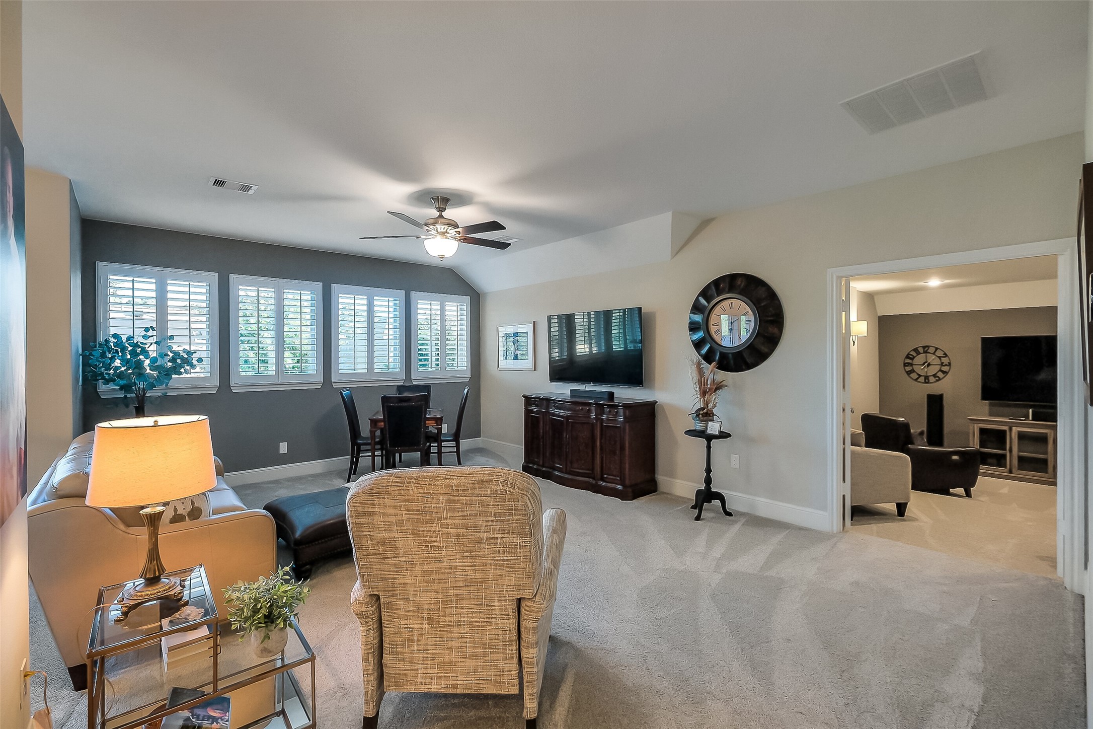 Upstairs, this spacious living or game room offers plush carpet and a bold accent wall, with an easy flow into the adjoining media room  ideal for movie nights or game day.