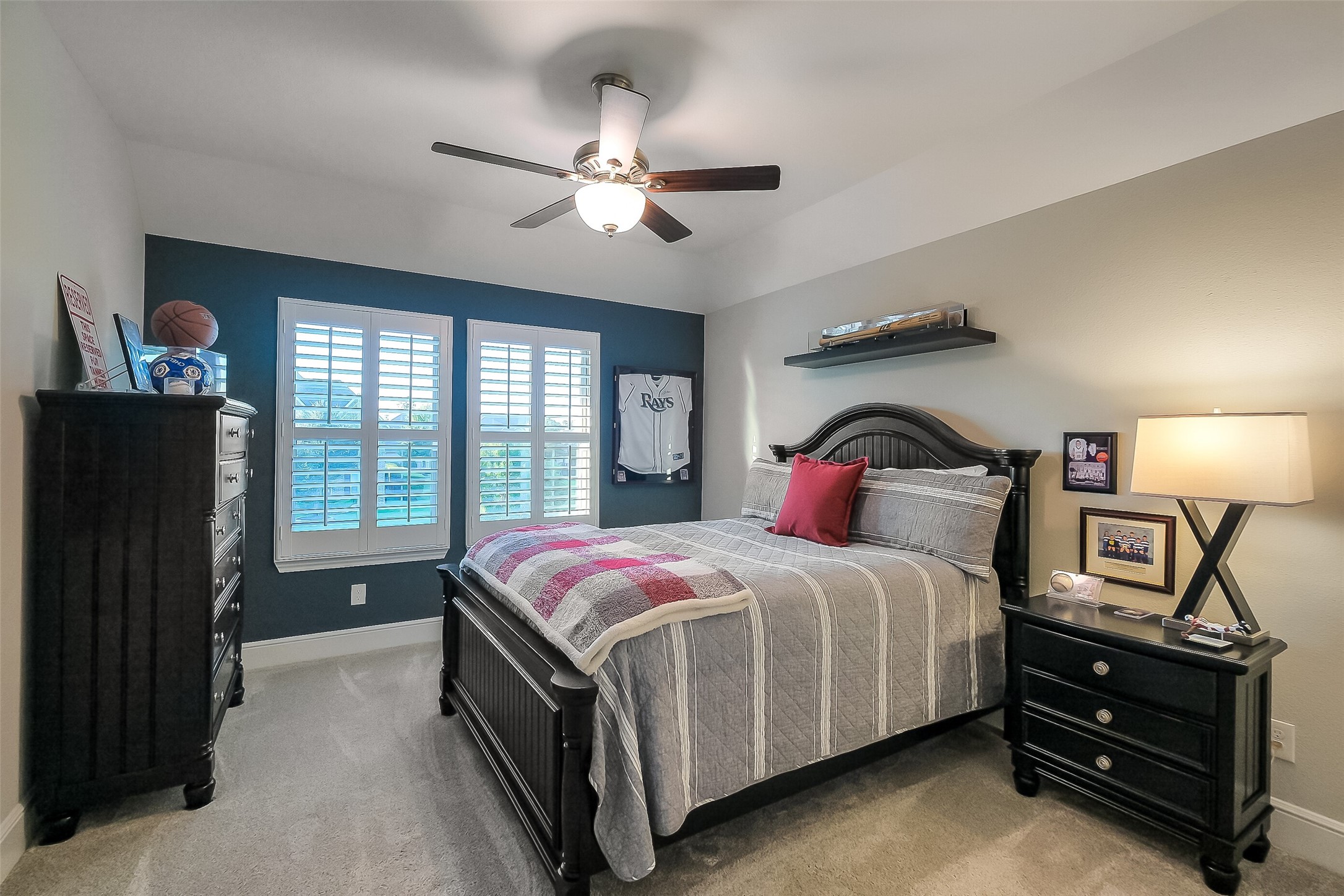 This spacious secondary bedroom offers plenty of room to make it your own, with plantation shutters, a ceiling fan, and generous wall space for furniture and dcor.