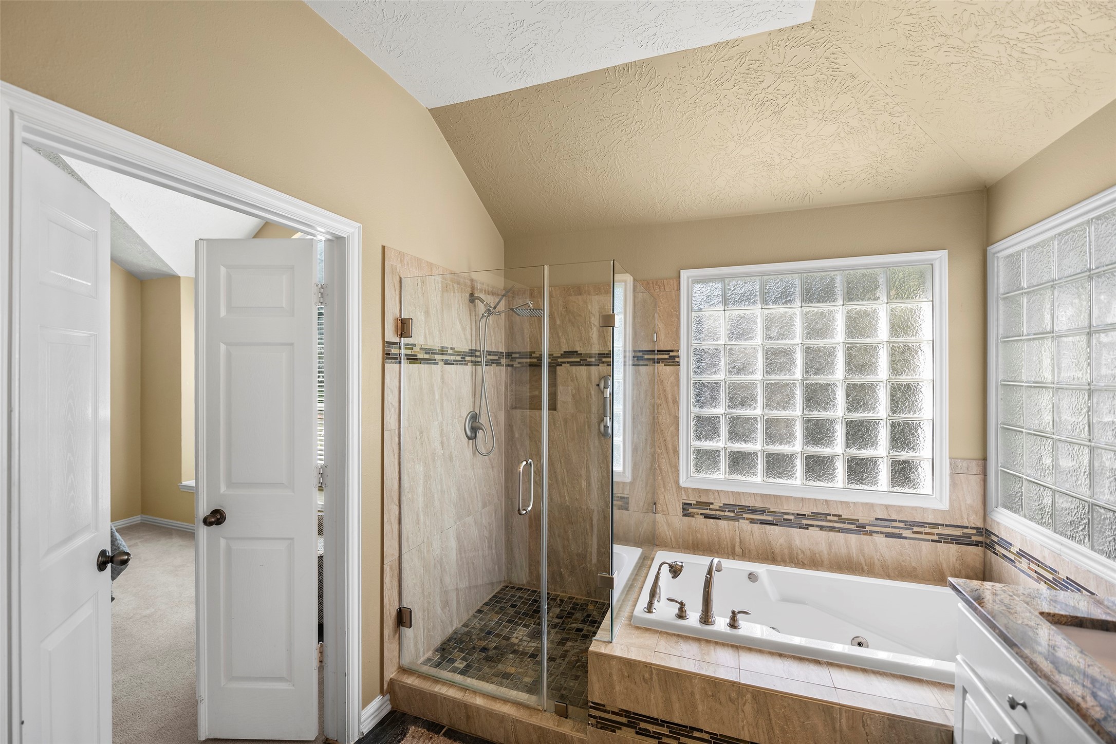 En Suite boasts a spa like feel with soaker jet tub and frameless shower with custom tile work.