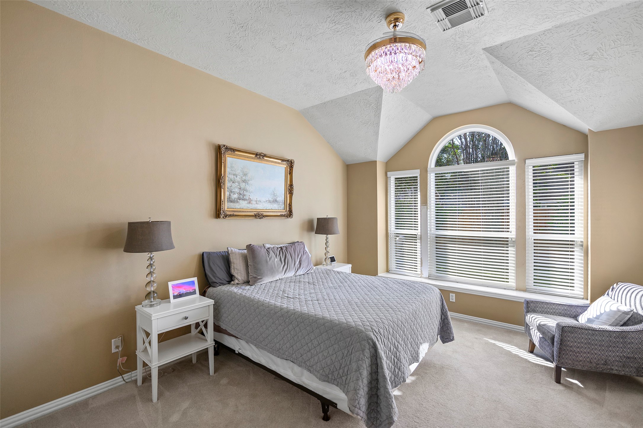 The primary room with custom light fixture, vaulted ceilings, and the natural light flowing through the new windows.