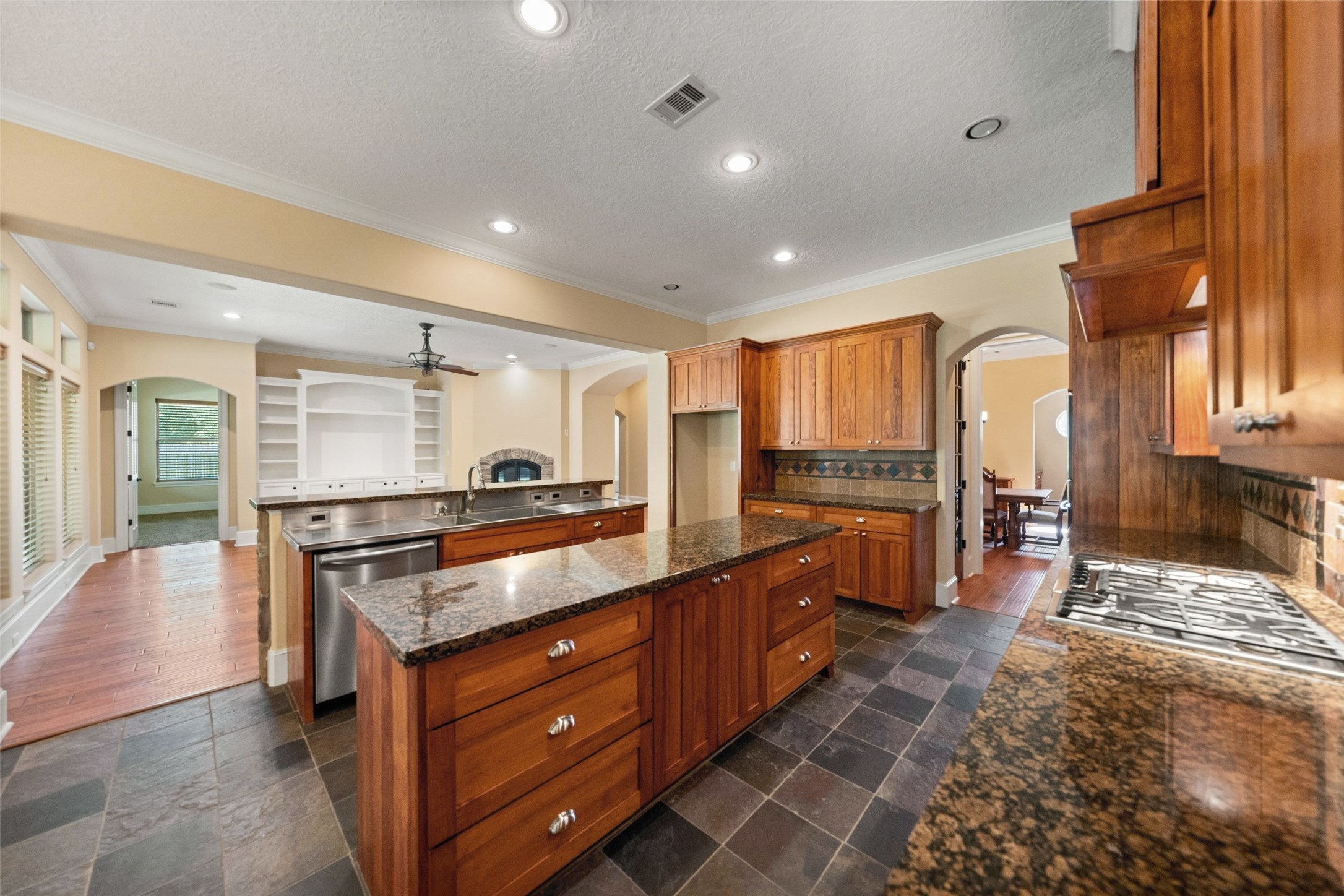 Expansive kitchen with custom cabinets, granite countertops, and sleek stainless steel prep areas.