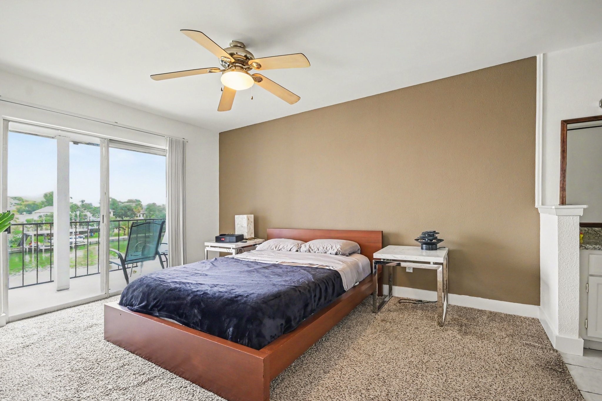 Spacious primary bedroom with waterfront balcony access