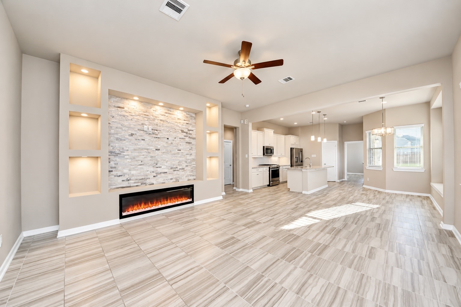 Open living and dining areas featuring beautiful tile flooring, recessed lighting, and a modern electric fireplace.