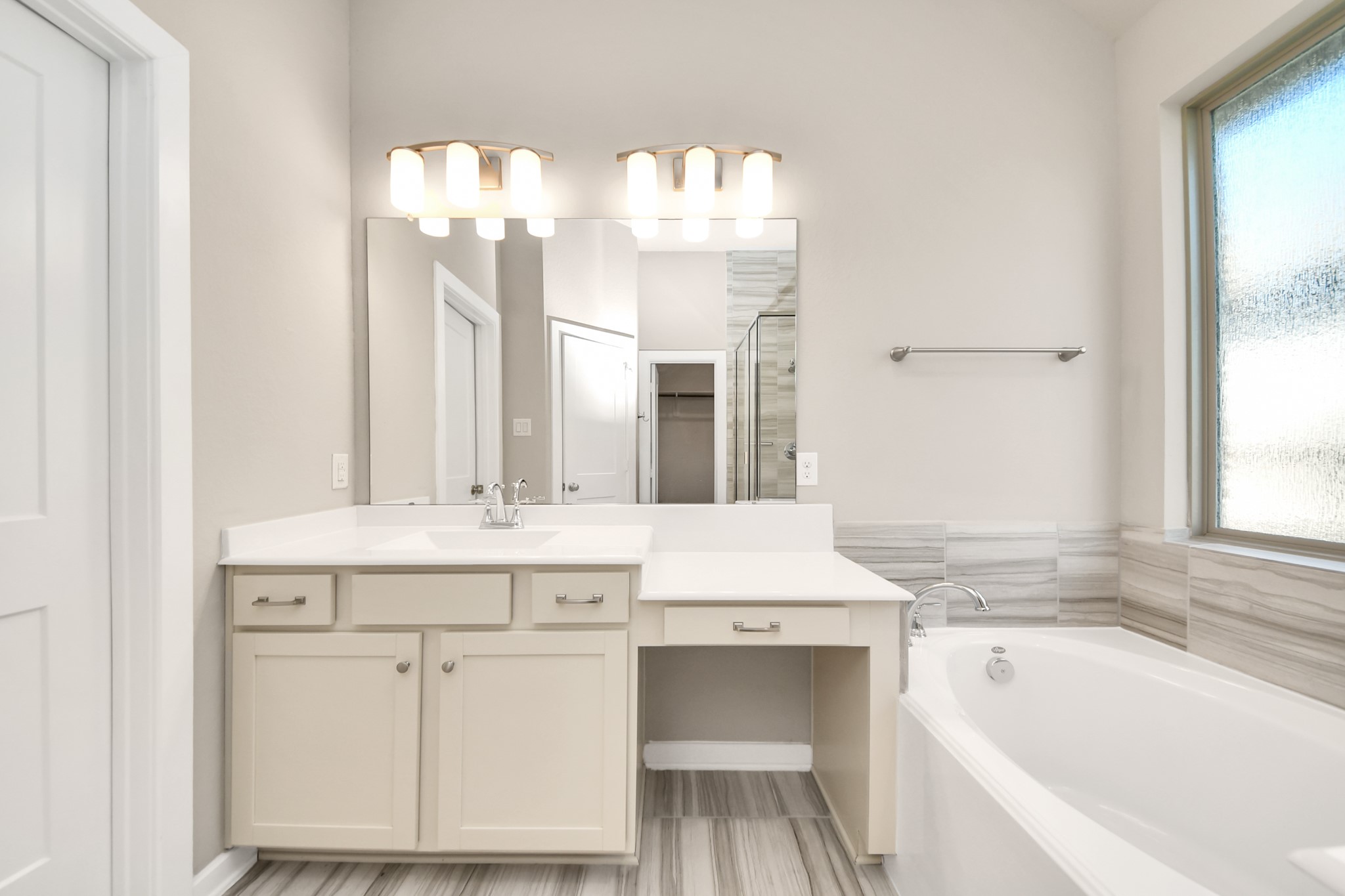 Additional view of the primary bathroom showcasing the spacious vanity and elegant finishes.