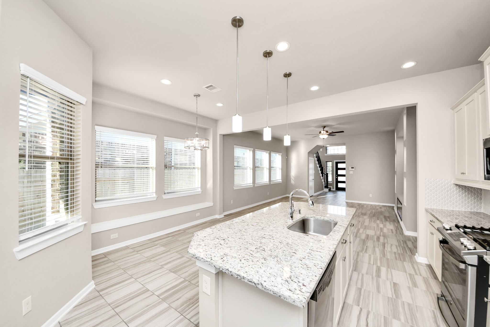 Bright and inviting kitchen featuring a large center island, ample cabinetry, and stainless steel appliances.