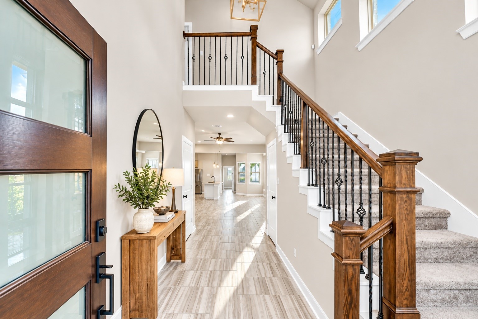 Welcoming entryway with soaring ceilings, an elegant staircase, and abundant natural light.