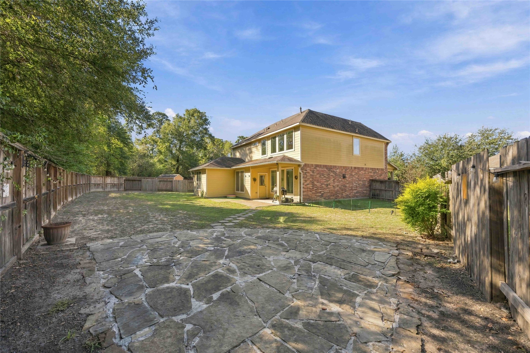 A stone pathway winds through the backyard, the perfect last stroll before you call this home.