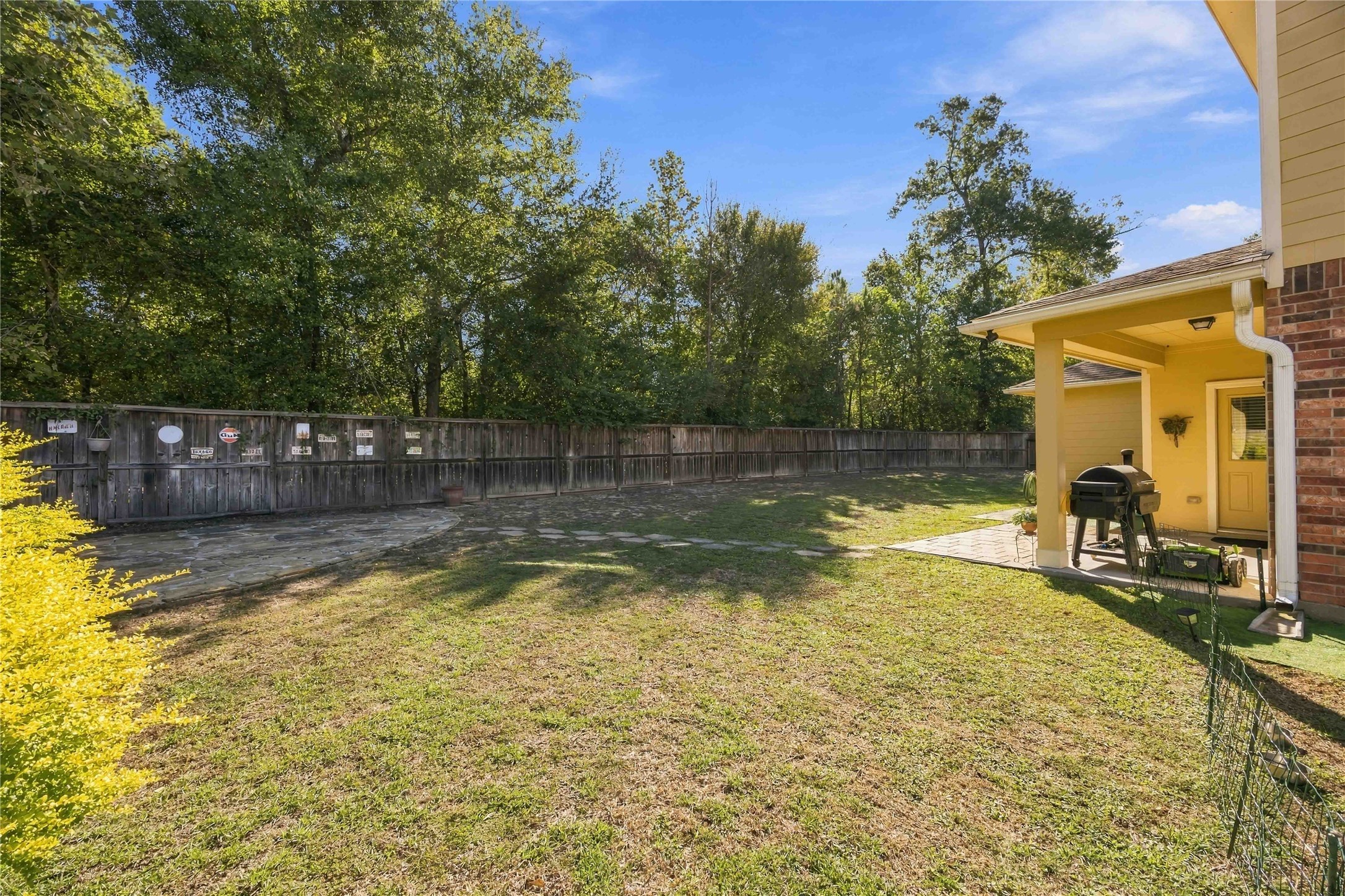 Picture slow mornings or evening gatherings on the covered patio, overlooking the lawn and tree line.