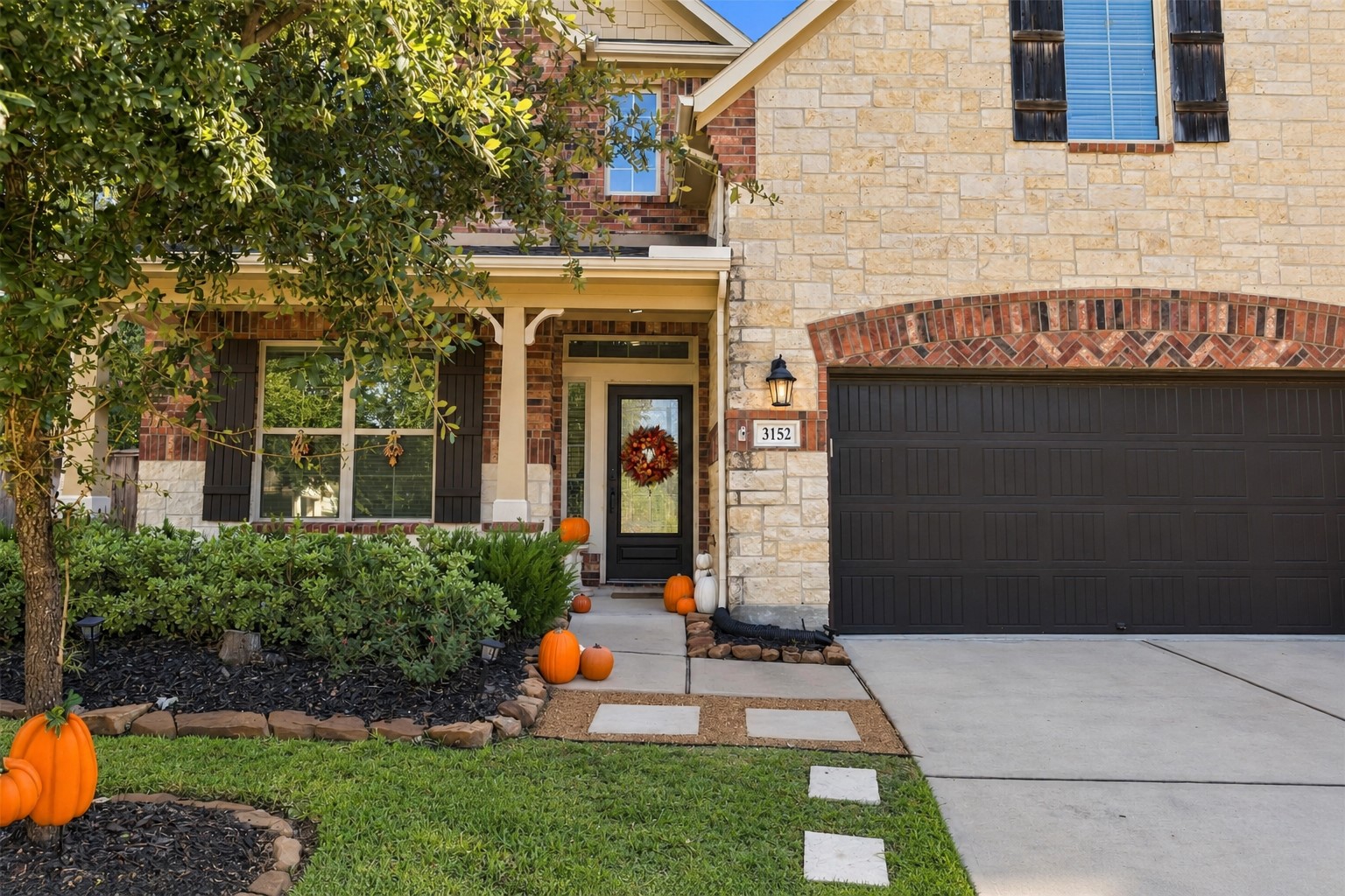 A covered entry framed by manicured landscaping makes coming home feel like an occasion.