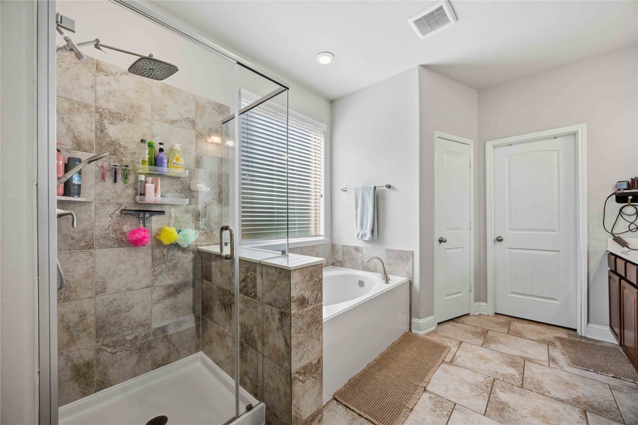 The primary bath feels like a spa, with a glass-enclosed shower and a soaking tub.