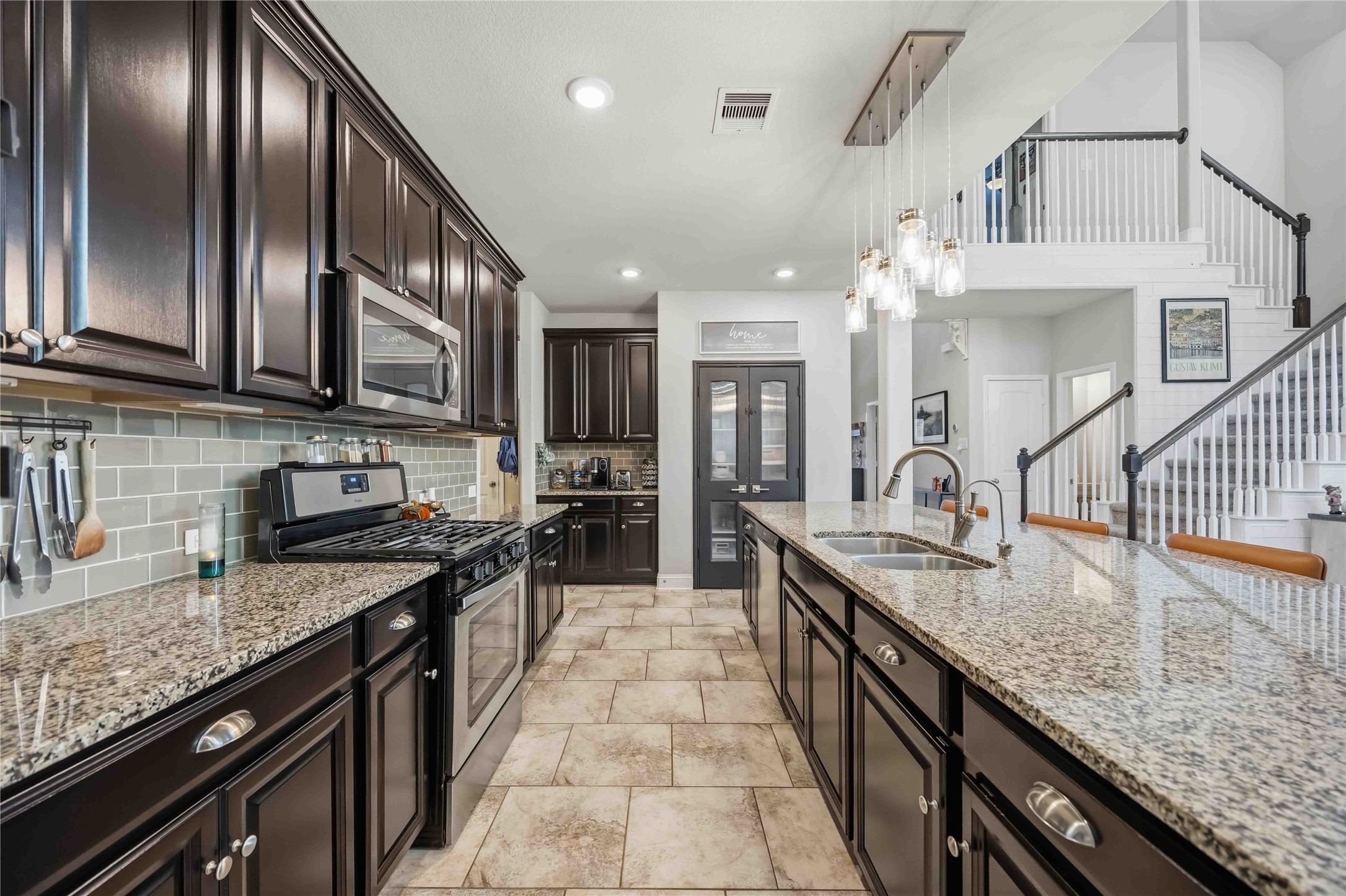 Granite countertops, a modern backsplash, and rich cabinetry give this gourmet kitchen its polish.