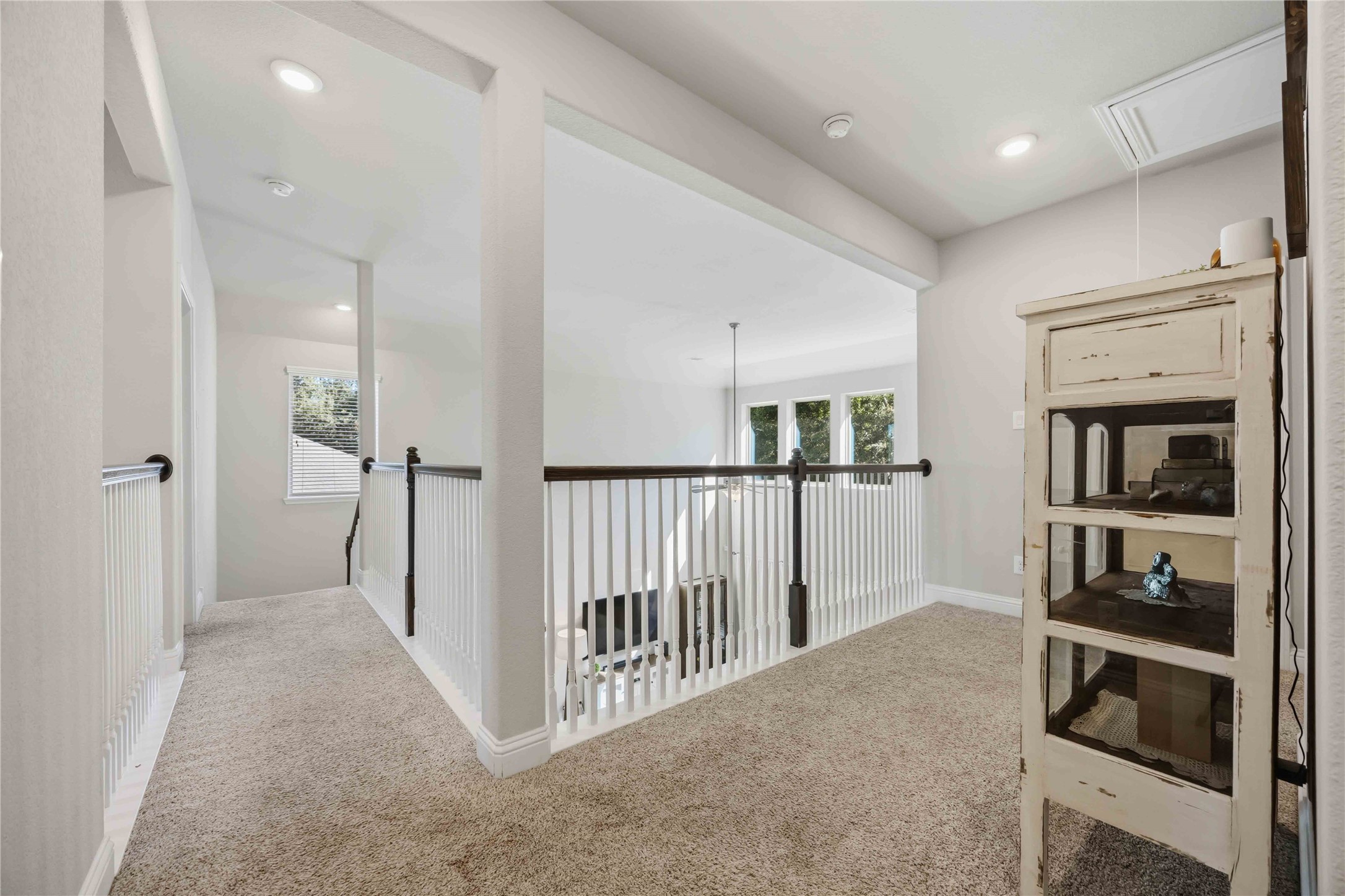 An open-railed landing connects the upstairs and looks out over the two-story living space.