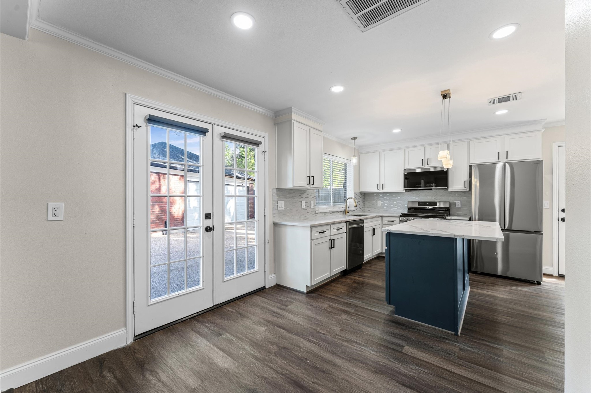 The updated kitchen features white cabinetry, stainless steel appliances, and a center island, with the Breakfast Room alongside. The updated kitchen features white cabinetry, stainless steel appliances, and a center island, with the Breakfast Room alongside.