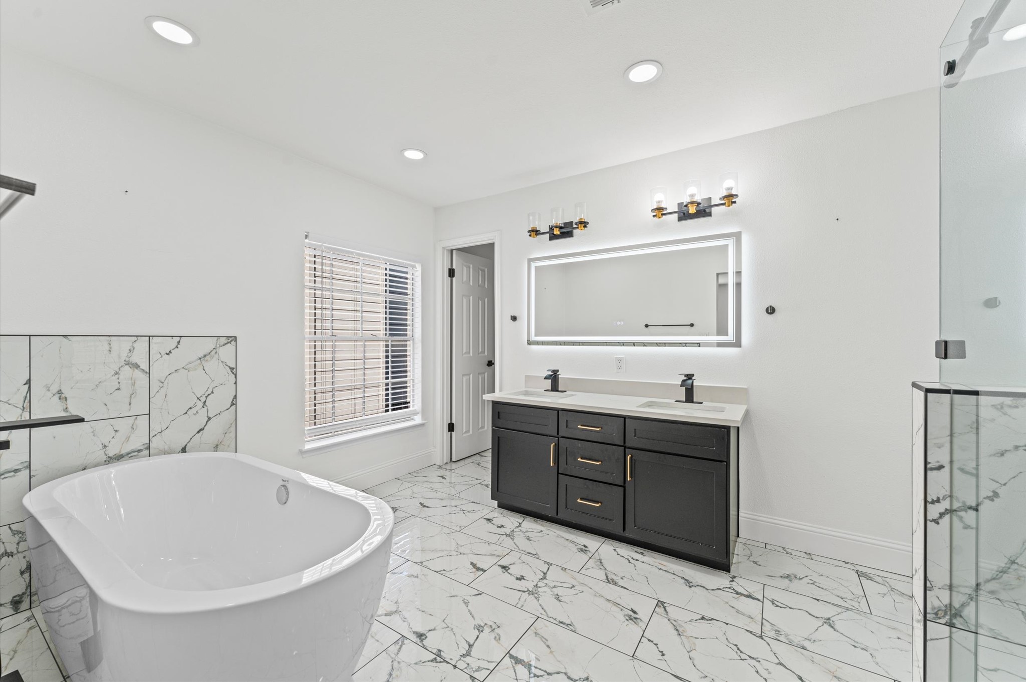 Spacious Primary Bath features double sinks, a freestanding soaking tub, and a separate walk-in shower.