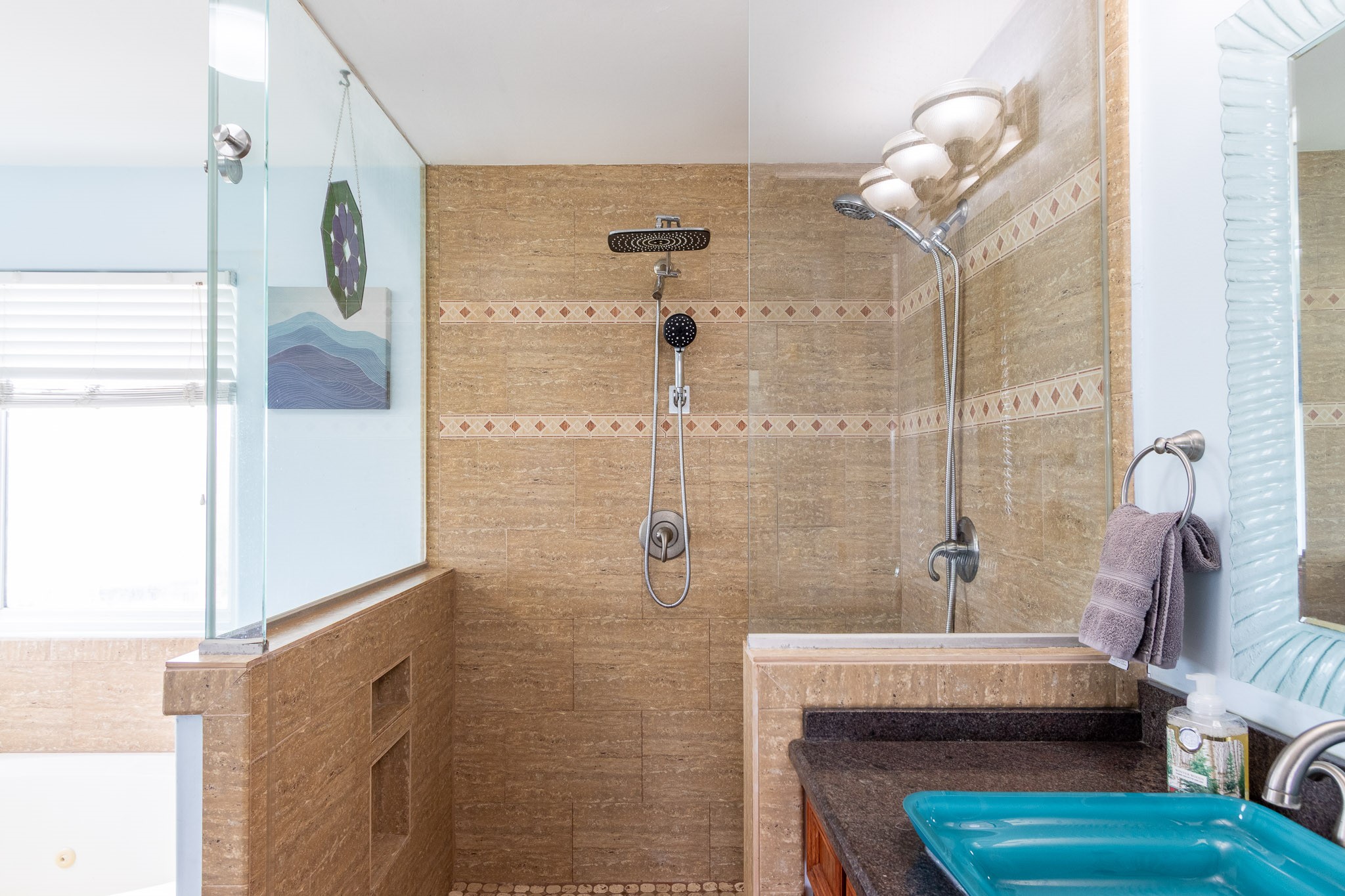 Primary ensuite bathroom with dual shower heads. Glass vessel sinks