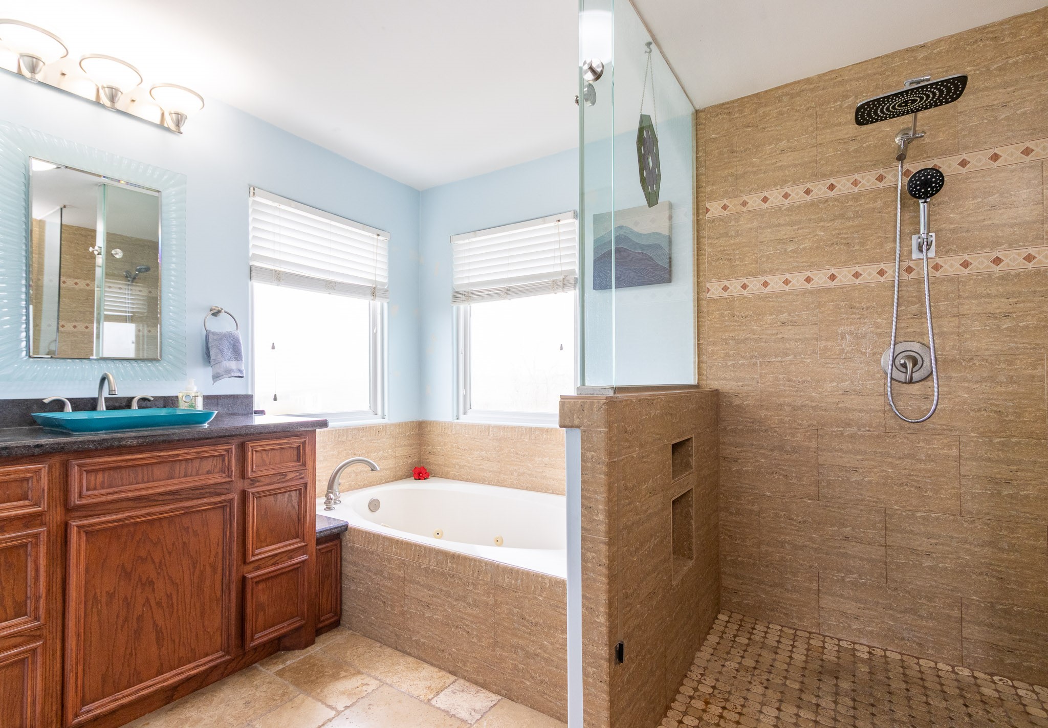 Primary ensuite bathroom with dual shower heads. and jetted spa tub. Glass vessel sinks.