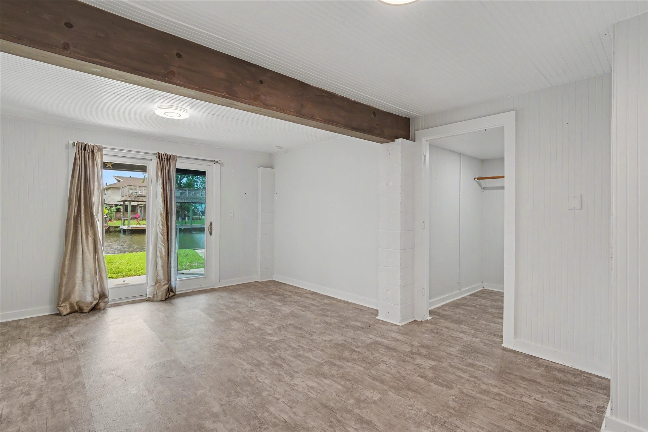 This bedroom/flex room has a very large walk in closet. The natural colored wood beam is a nice touch