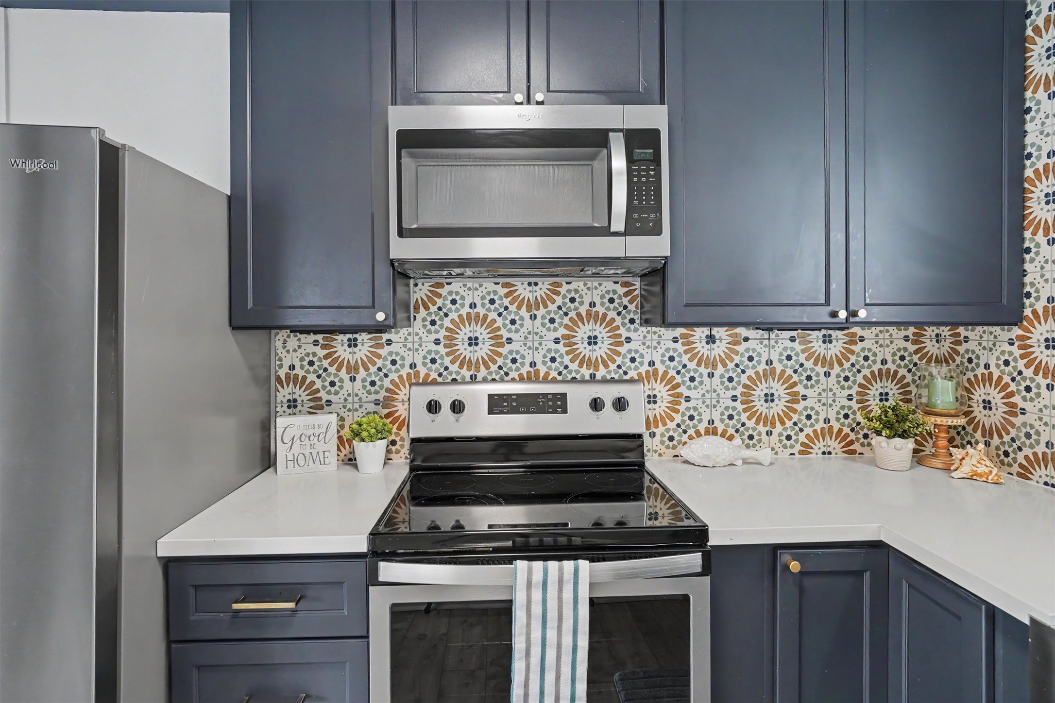 Photo of the updated cabinets and appliances with the modern backsplash