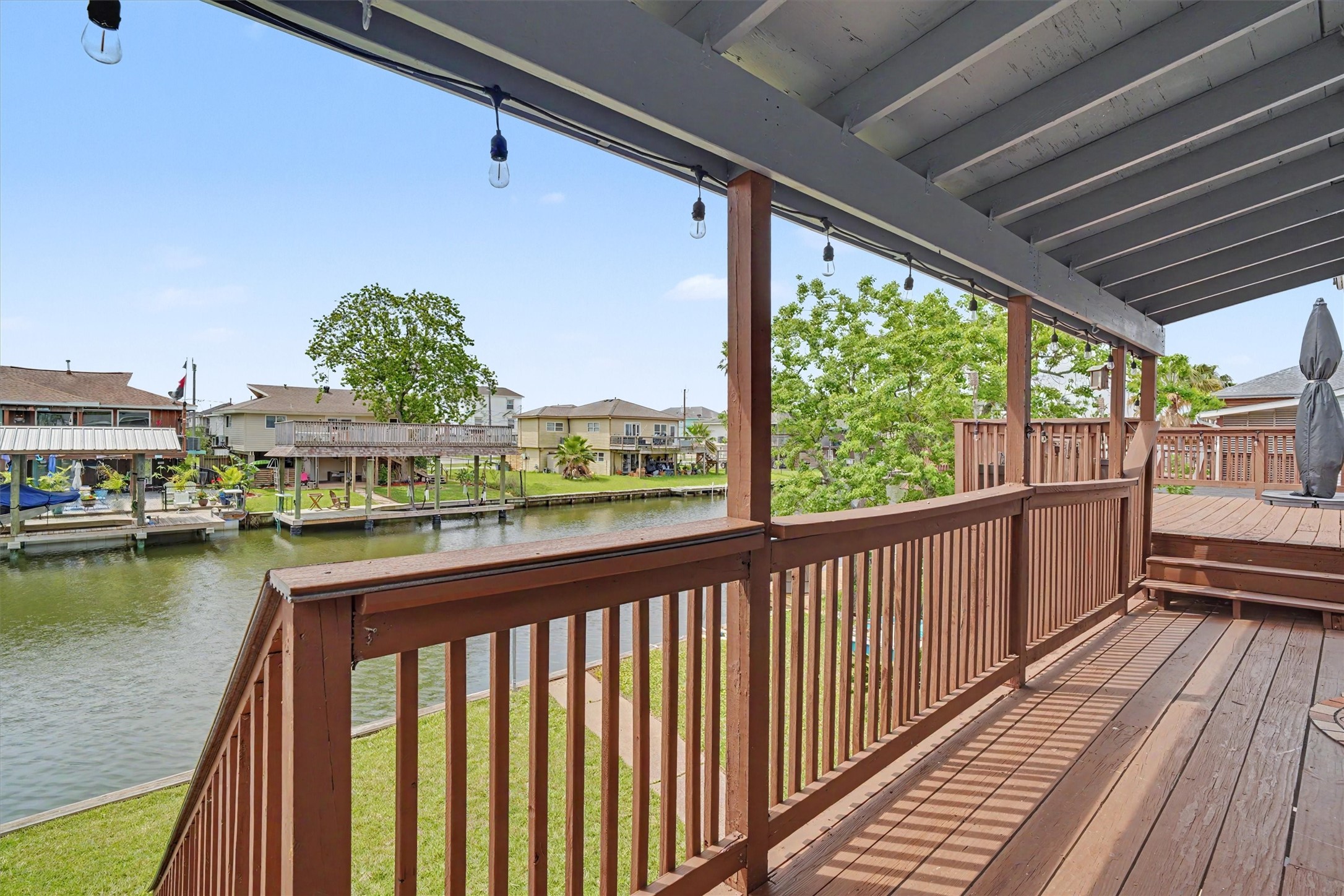 Upstairs covered porch with beautiful water view. This leads to the side yard upper party deck