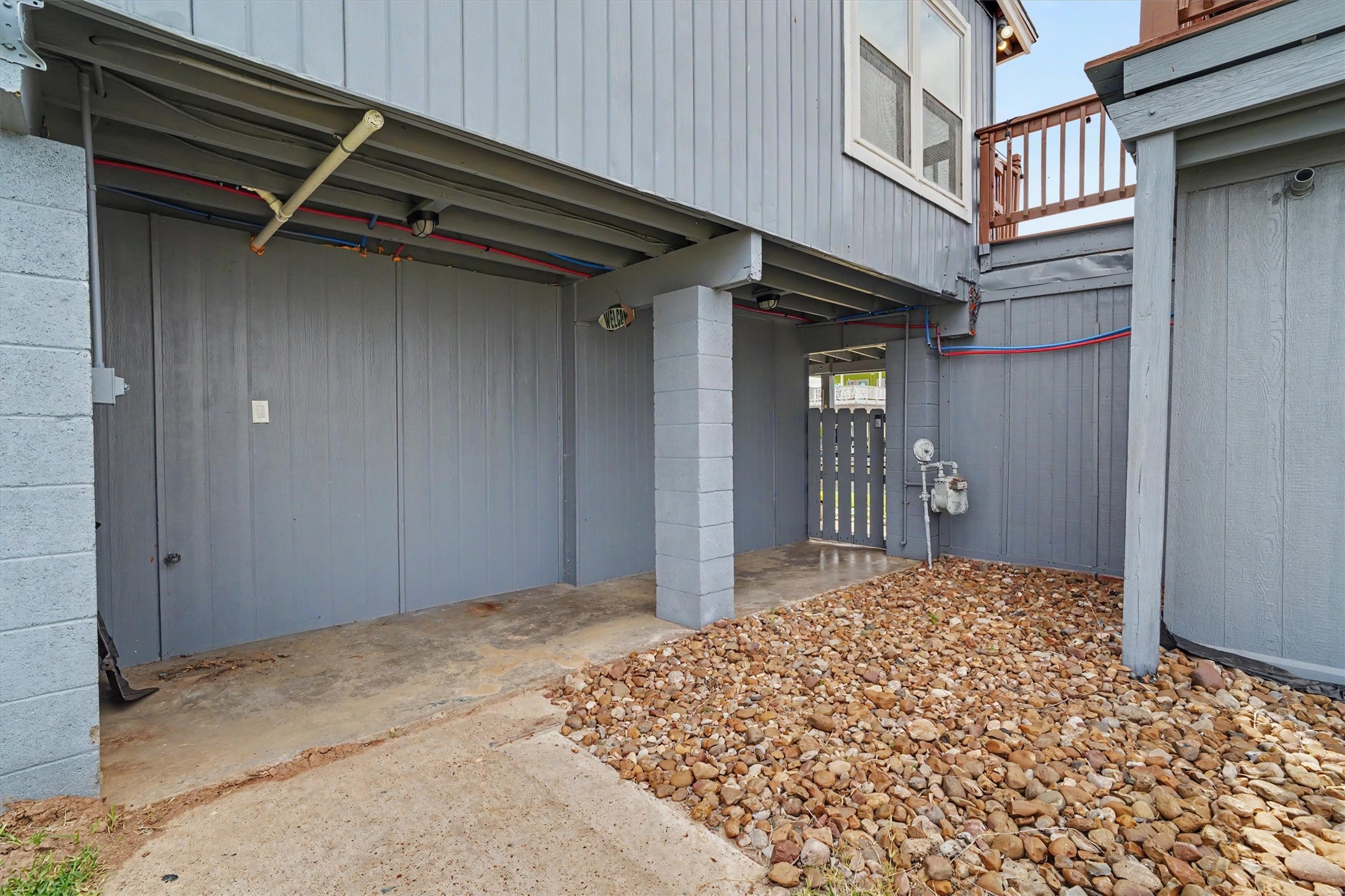 Side yard with rock landscape and gate to the water side of the home