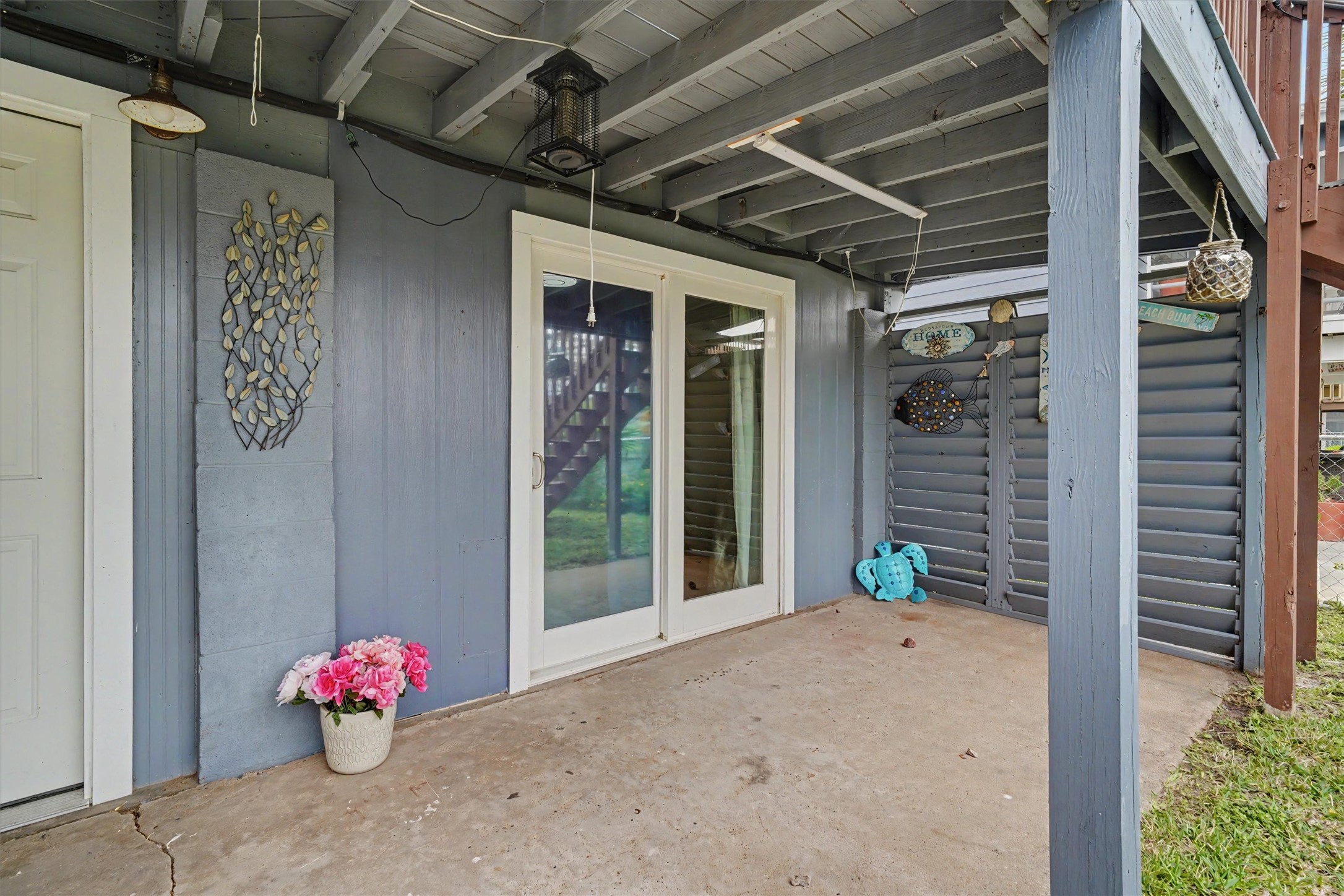 Downstairs sliding door into a bedroom. Covered entertainment area downstairs for exterior furniture and notice the privacy slats