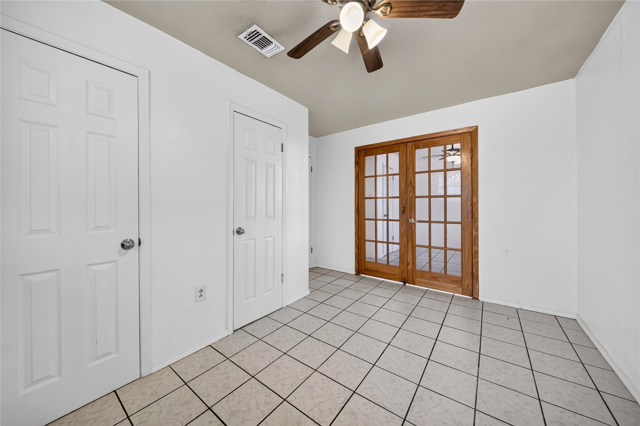 Spacious bedroom with ample storage and French-door access.