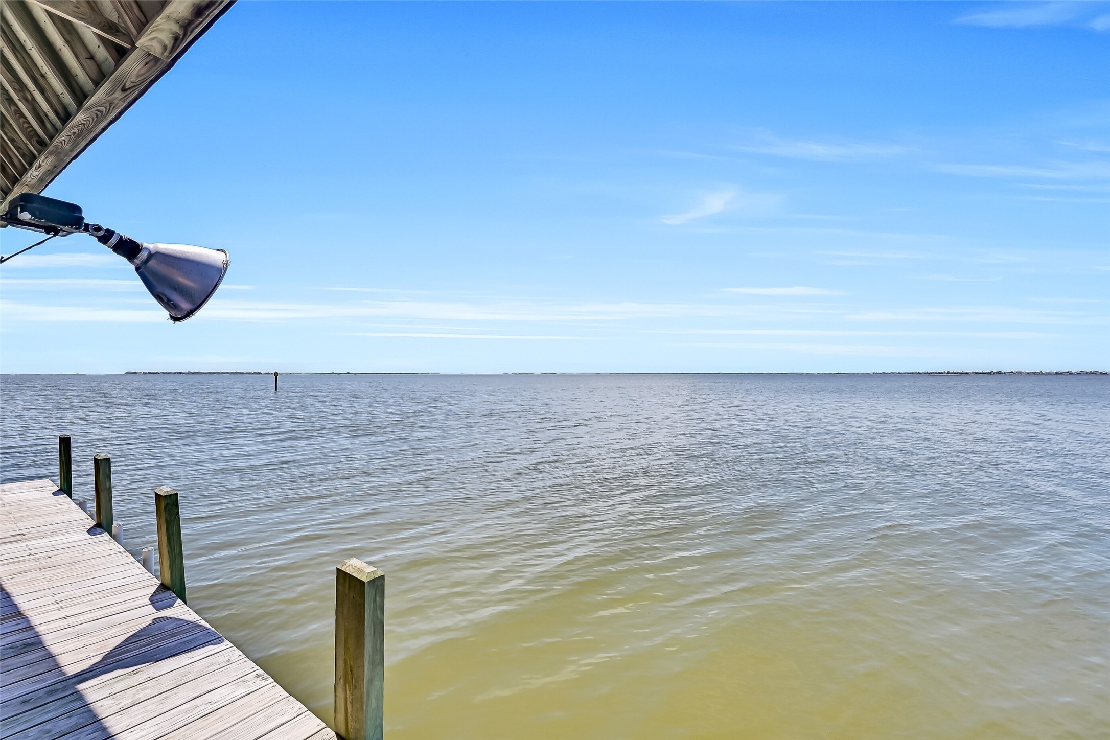 Waterfront living reaches its peak here. The dock is equipped with fishing lights that attract baitfish after dark, creating excellent opportunities to catch speckled trout, redfish, flounder, and black drum right from your own property. Combined with sweeping west-facing views across Jones Bay toward West Bay, it's the perfect place to spend evenings watching boats drift by and sunsets light up the horizon.