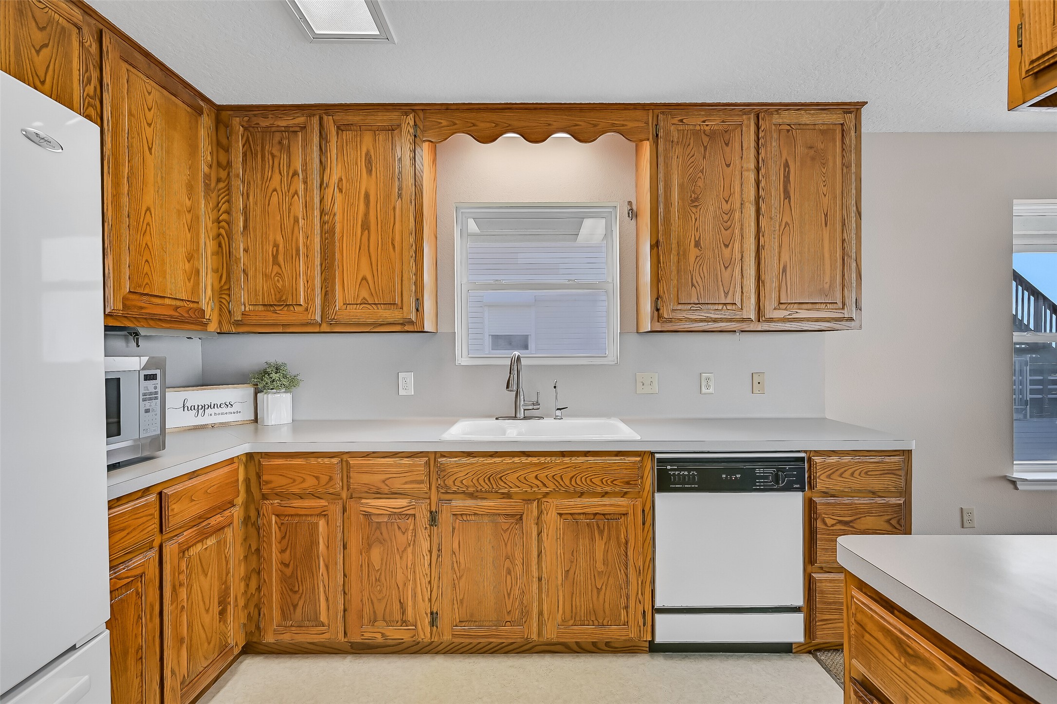 Offering ample cabinet storage, neutral countertops, a recently updated faucet, and excellent workspace, the kitchen balances functionality with convenience. Its central location keeps you connected to both the living spaces and the spectacular waterfront views.