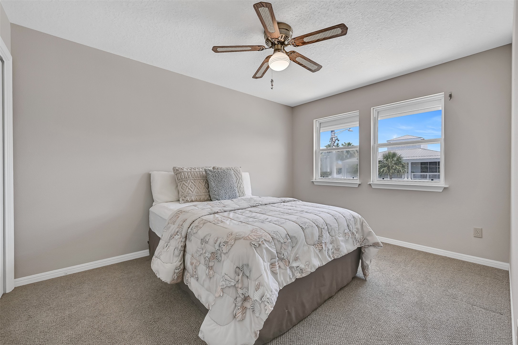 Located on the main living level, this comfortable secondary bedroom offers fresh Sherwin-Williams Natural Linen paint, Berber carpet, a ceiling fan, and easy access to the adjacent full bath. Ideal for guests who prefer to avoid stairs while enjoying the convenience of single-level living.