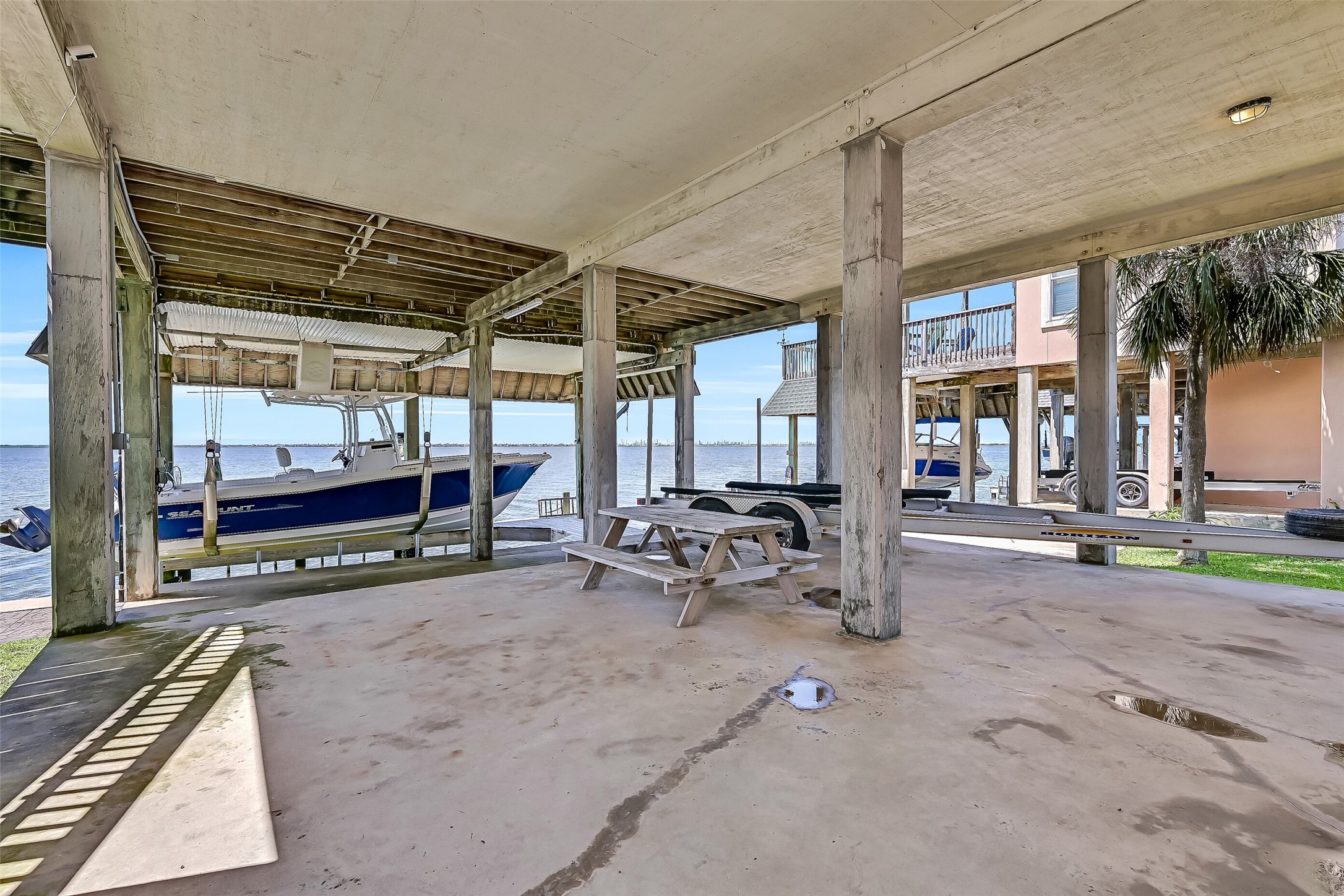 Beneath the home, you'll find additional covered waterfront space perfect for relaxing in the shade, gathering with friends, or preparing for a day on the water. With Jones Bay just steps away and panoramic water views in every direction, even the lower level captures the laid-back charm of island living.