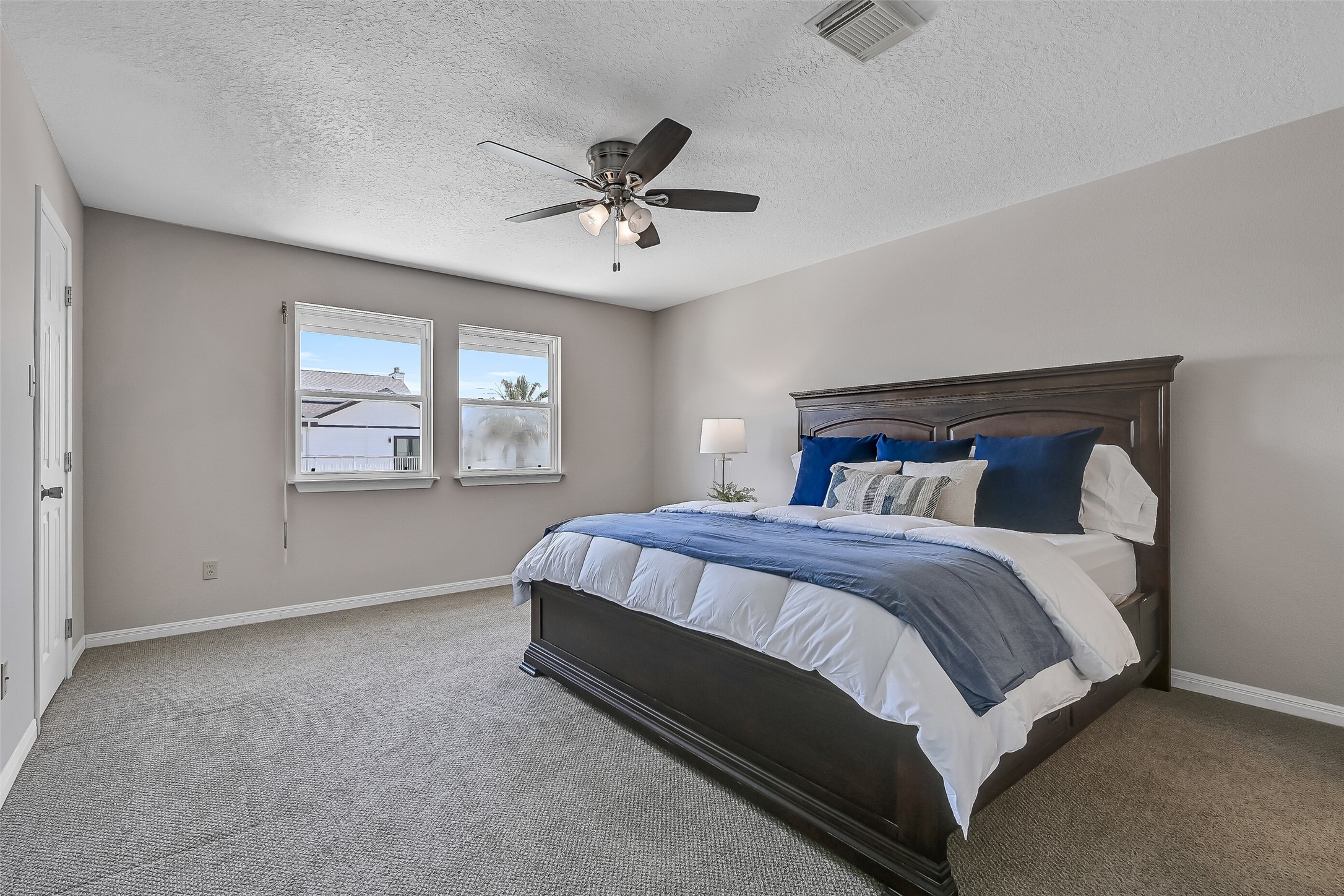 Located on the main living level, the primary suite allows owners to enjoy the kitchen, living room, waterfront deck, and bedroom without ever needing to go upstairs. Fresh Sherwin-Williams Natural Linen paint, Berber carpet, and a ceiling fan create a comfortable and inviting retreat.