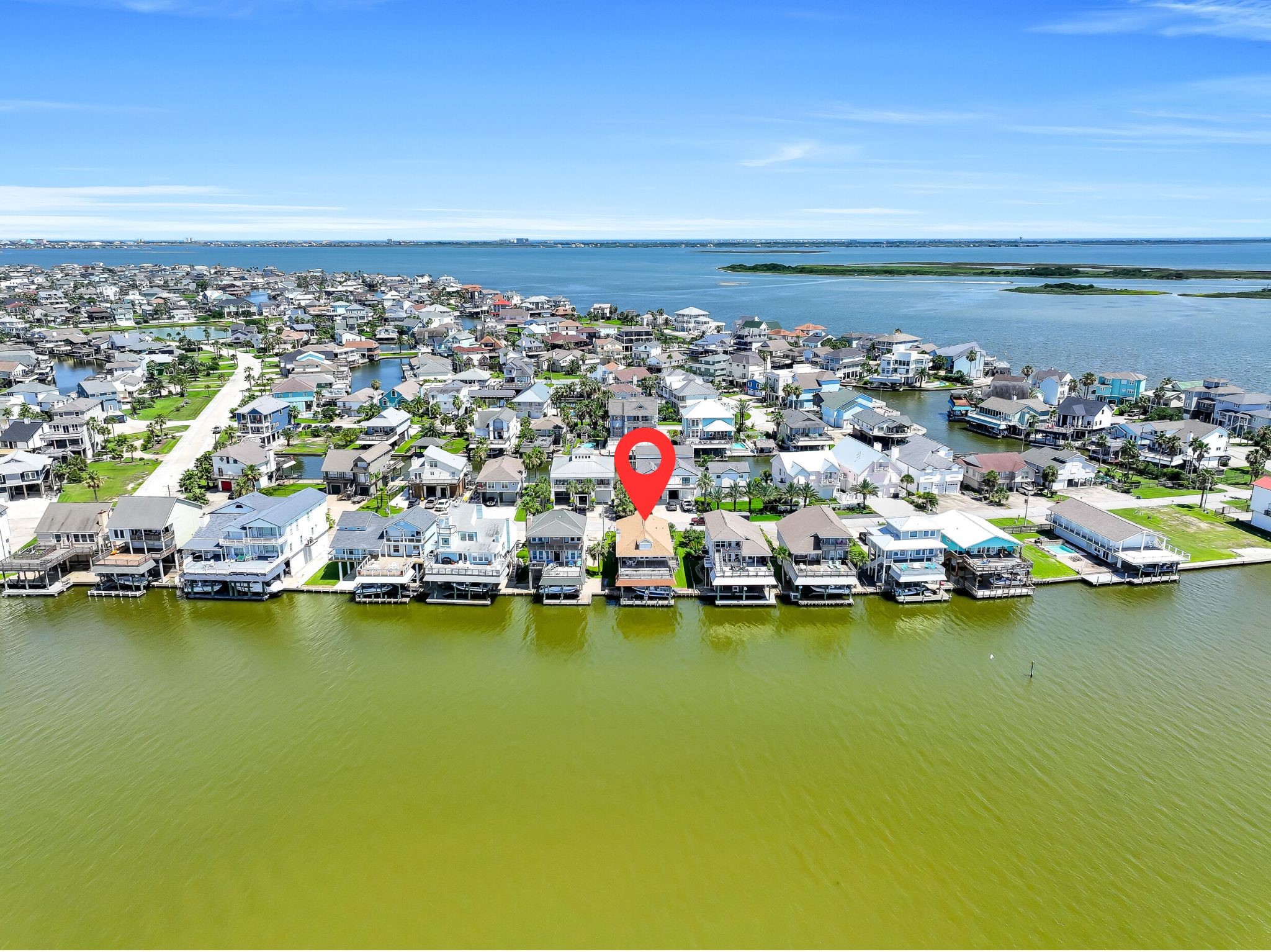This aerial perspective showcases the property's desirable waterfront location within one of the Gulf Coast's most sought-after boating communities. Enjoy the peaceful island atmosphere while remaining just minutes from Galveston beaches, restaurants, marinas, and convenient access back to the Houston area.