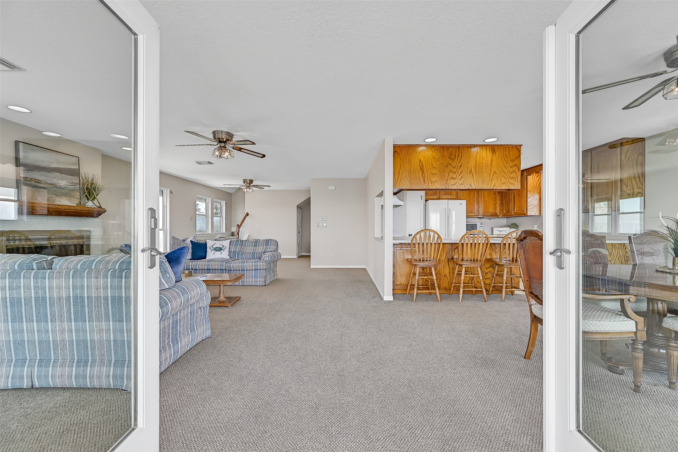 Step through the second-floor entry and into an open-concept living, dining, and kitchen area designed to maximize the home's incredible waterfront setting. Fresh Sherwin-Williams Natural Linen paint and expansive gathering spaces create a comfortable backdrop for everyday coastal living.