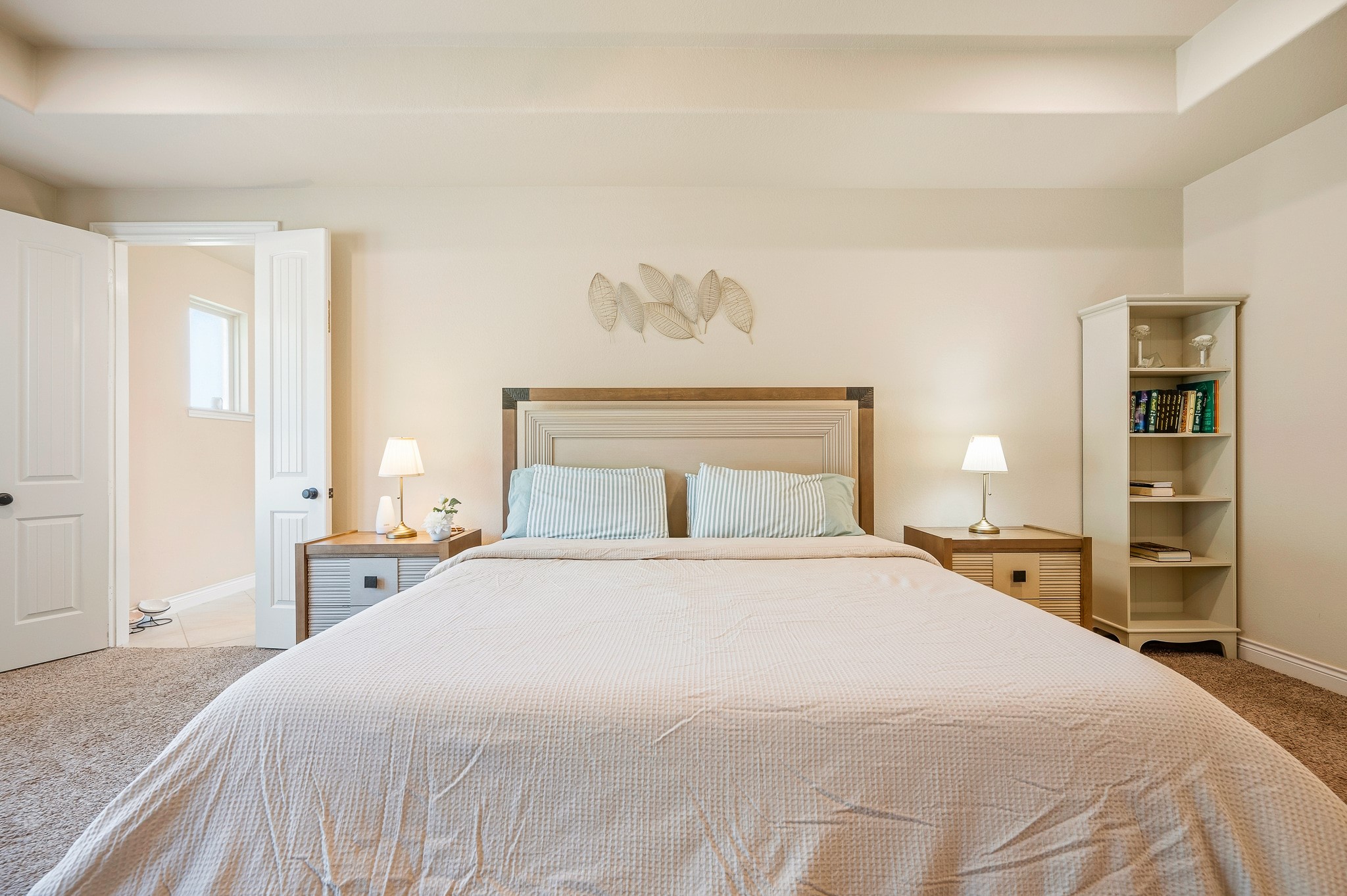 Experience the tranquility of a spacious bedroom, featuring a cozy bed, soft lighting, and a calming neutral palette for the perfect serene retreat.