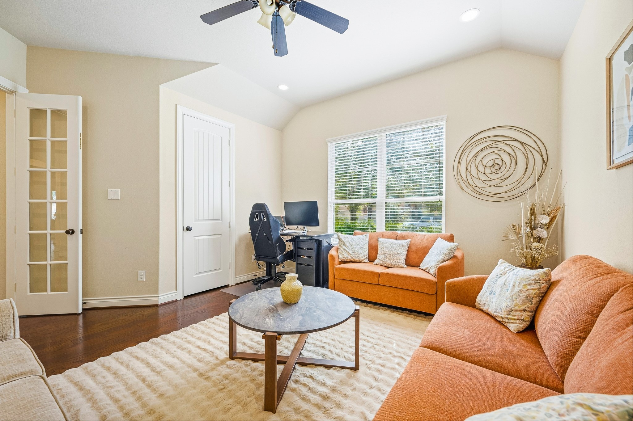 Cozy and inviting, this living area features warm-toned seating, a central coffee table, and an abundance of natural light through large windows, perfect for relaxation or a chic home office.
