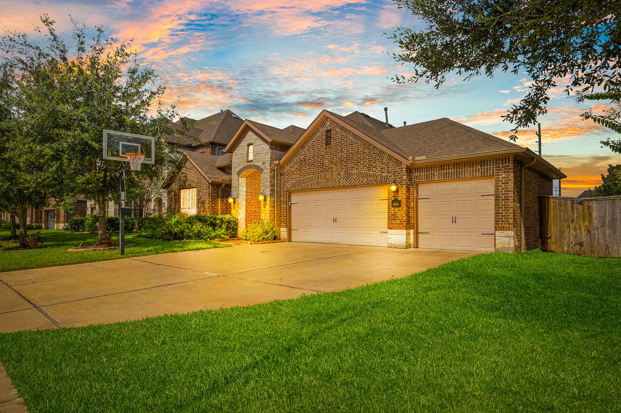 Experience the charm of this stunning brick home with a spacious three-car garage, beautifully landscaped front yard, and a basketball hoop, all set against a breathtaking sunset backdrop. Experience the charm of this stunning brick home with a spacious three-car garage, beautifully landscaped front yard, and a basketball hoop, all set against a breathtaking sunset backdrop.